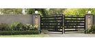 Black metal swing gate with stone pillars on a residential driveway