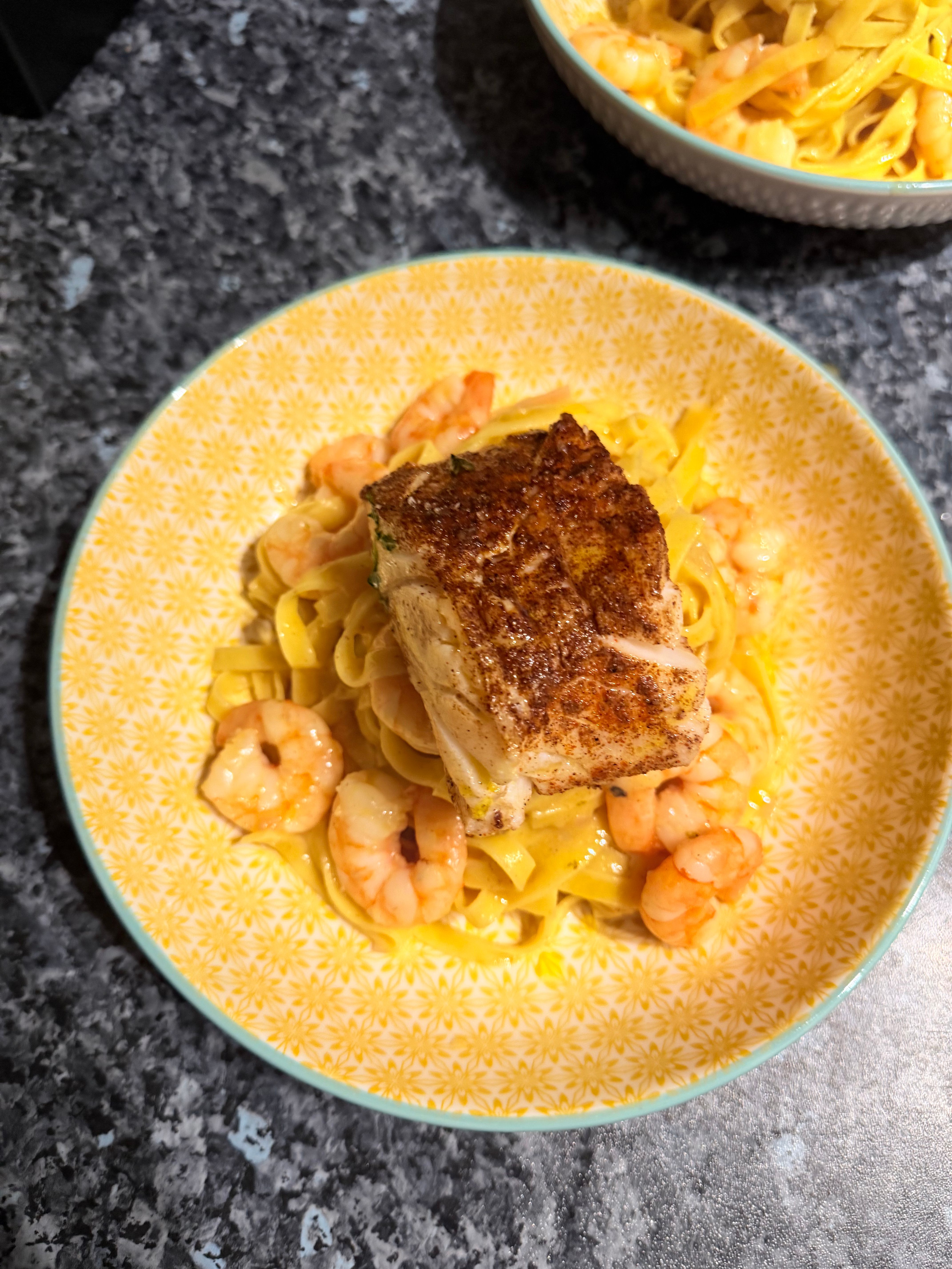 Pan-seared fish with creamy pasta and king prawns