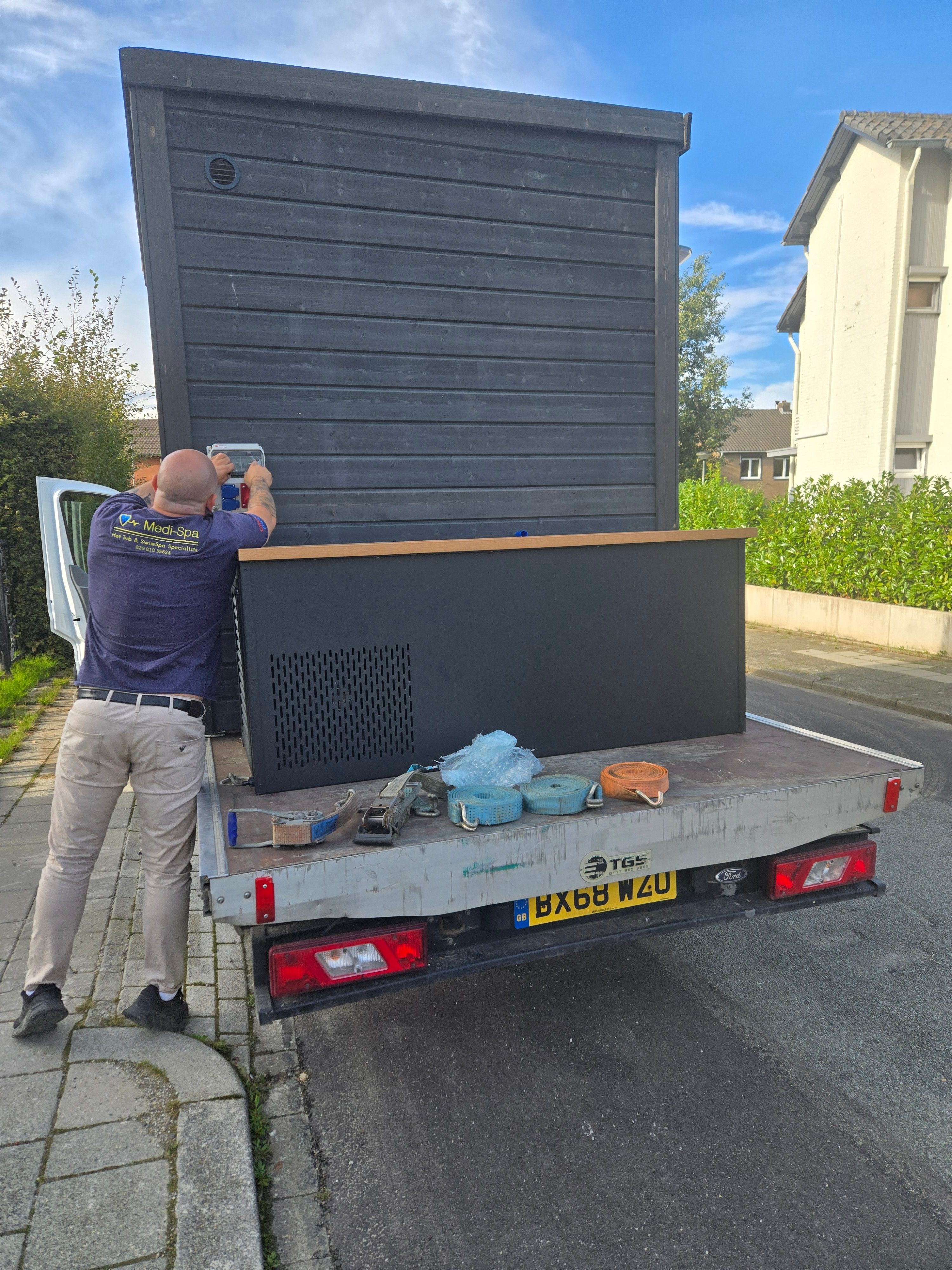 Medi-Spa technician securing a hot tub on the flatbed truck