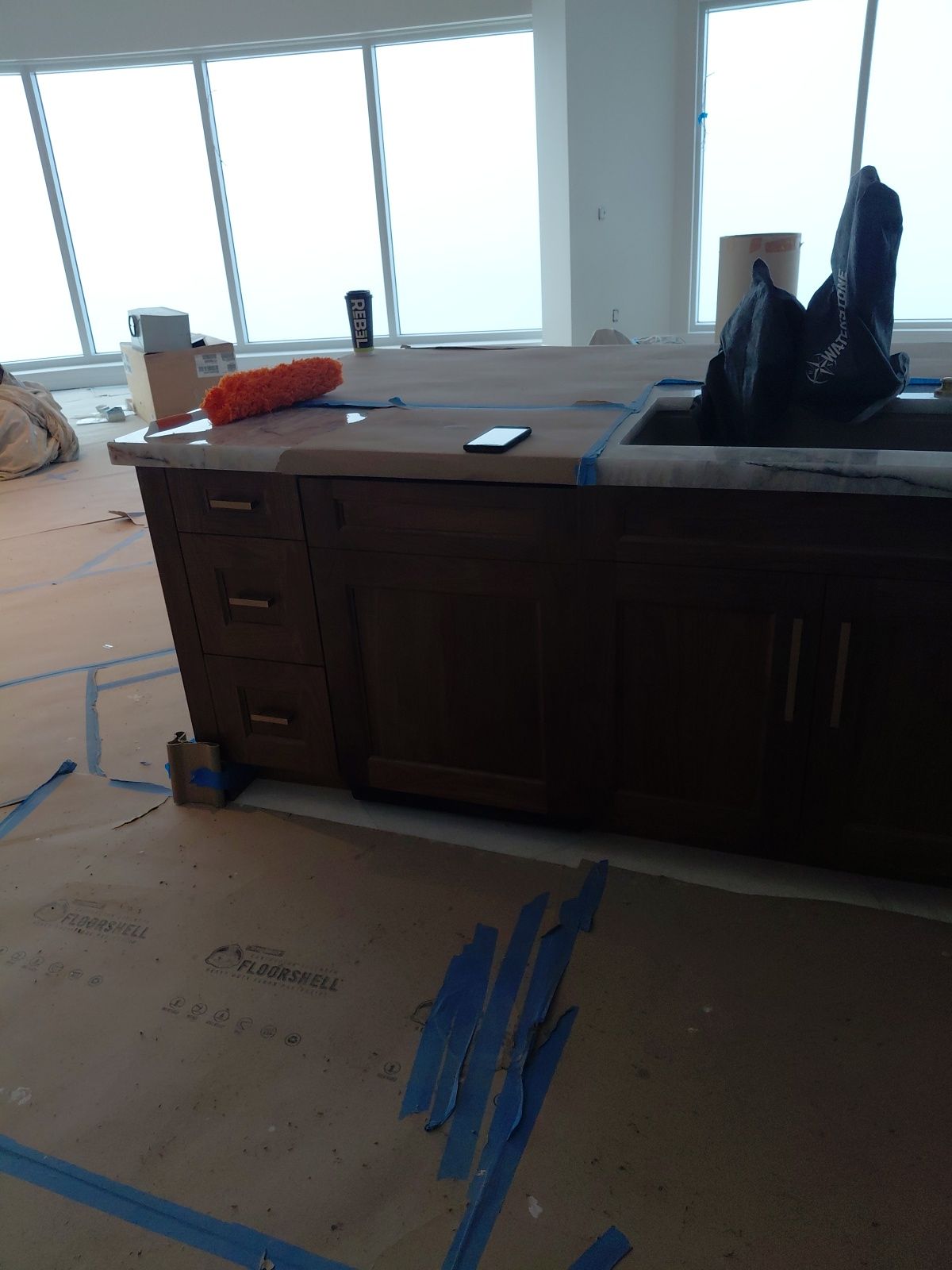 Kitchen island install with floor protection and finishing work in progress