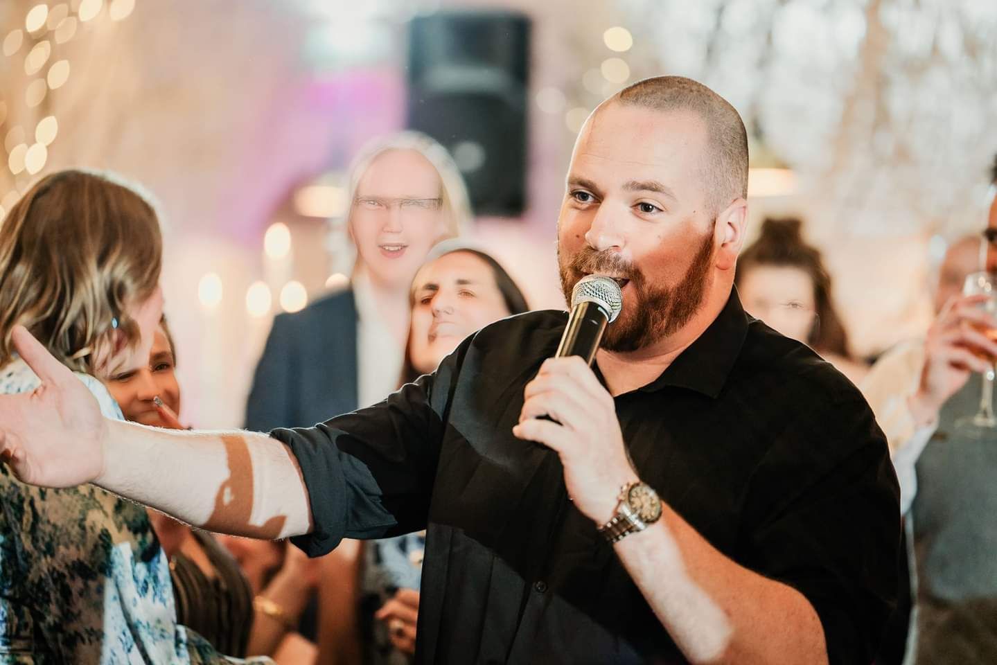 Ryan Wallace — The Opera Guy surrounded by smiling guests during a live performance