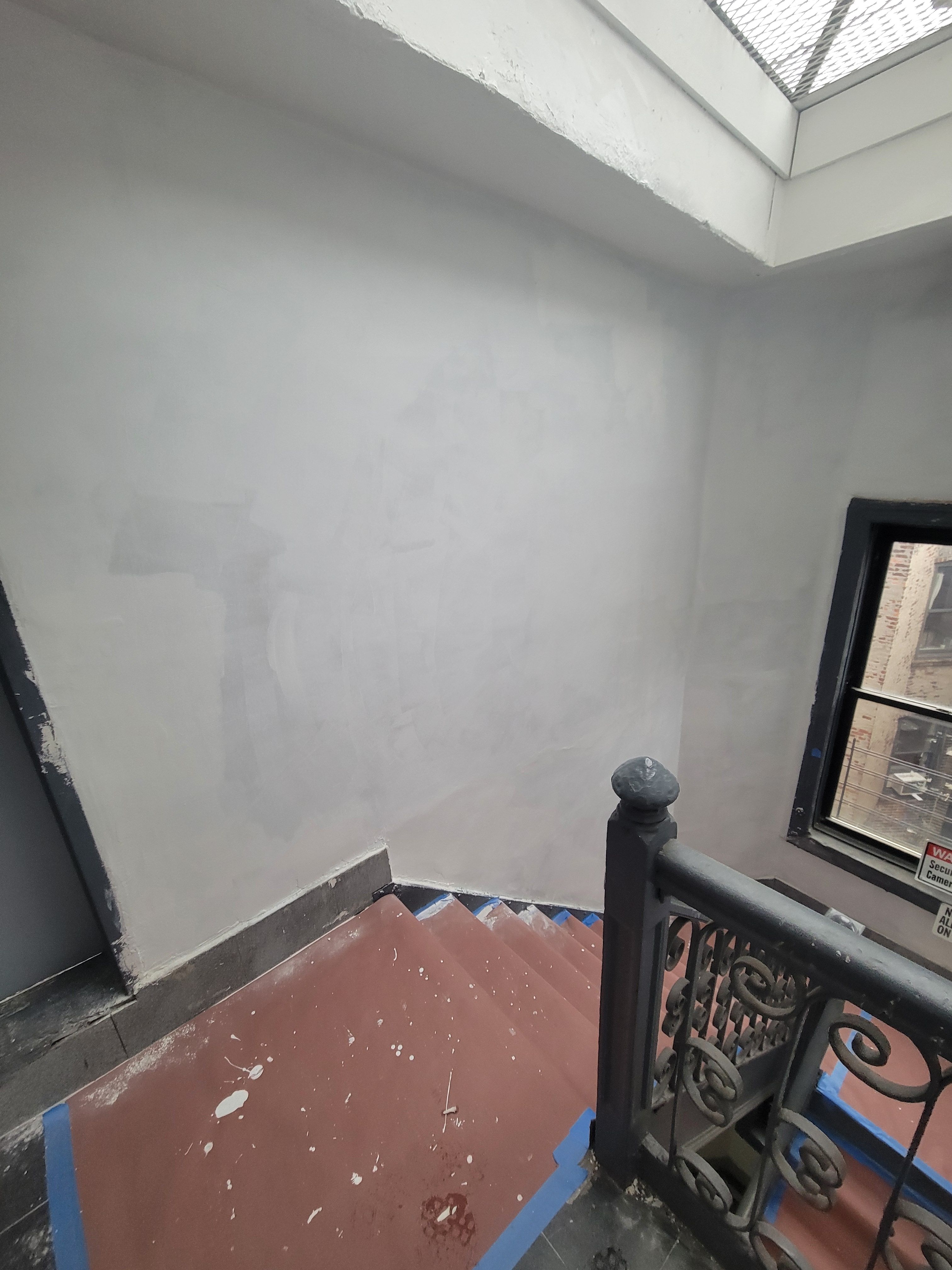 Roof landing stairwell repair - stairs with blue painter's tape and freshly patched walls