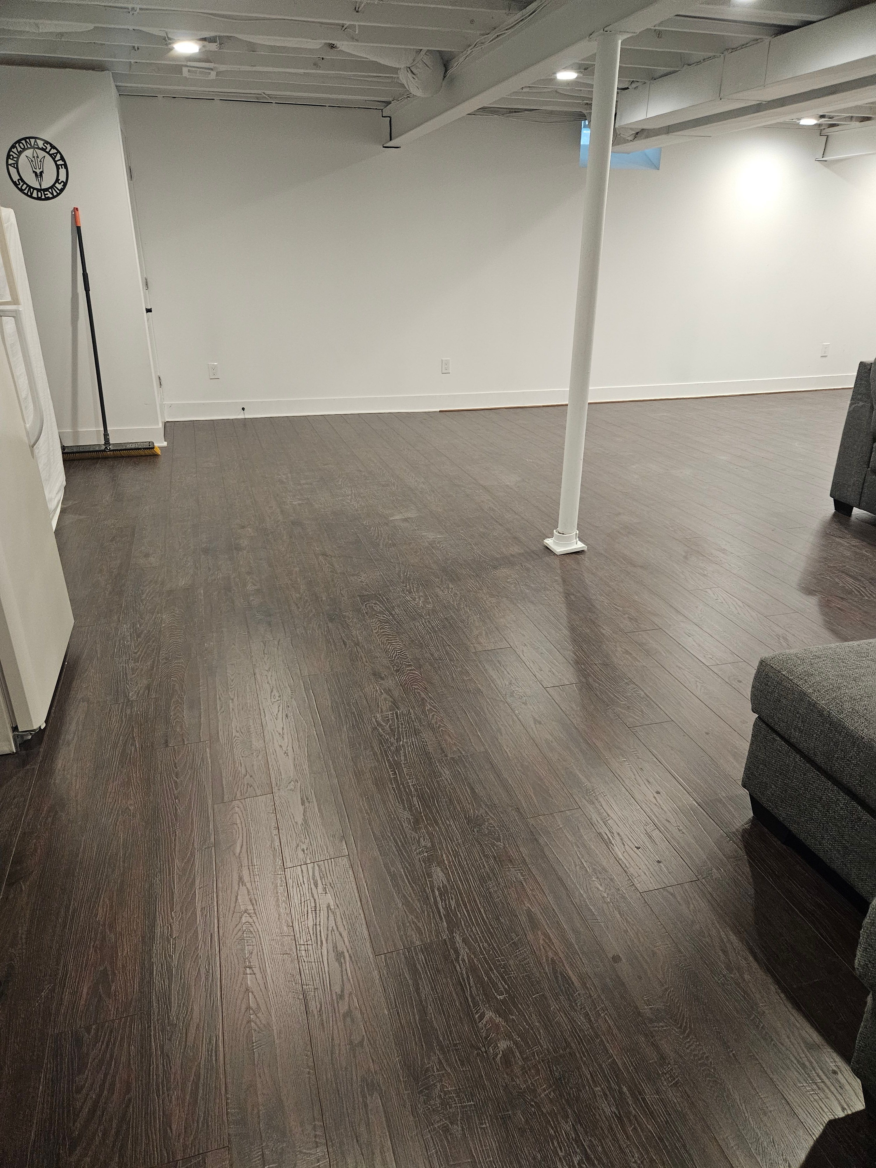 Basement living space with new flooring and recessed lighting