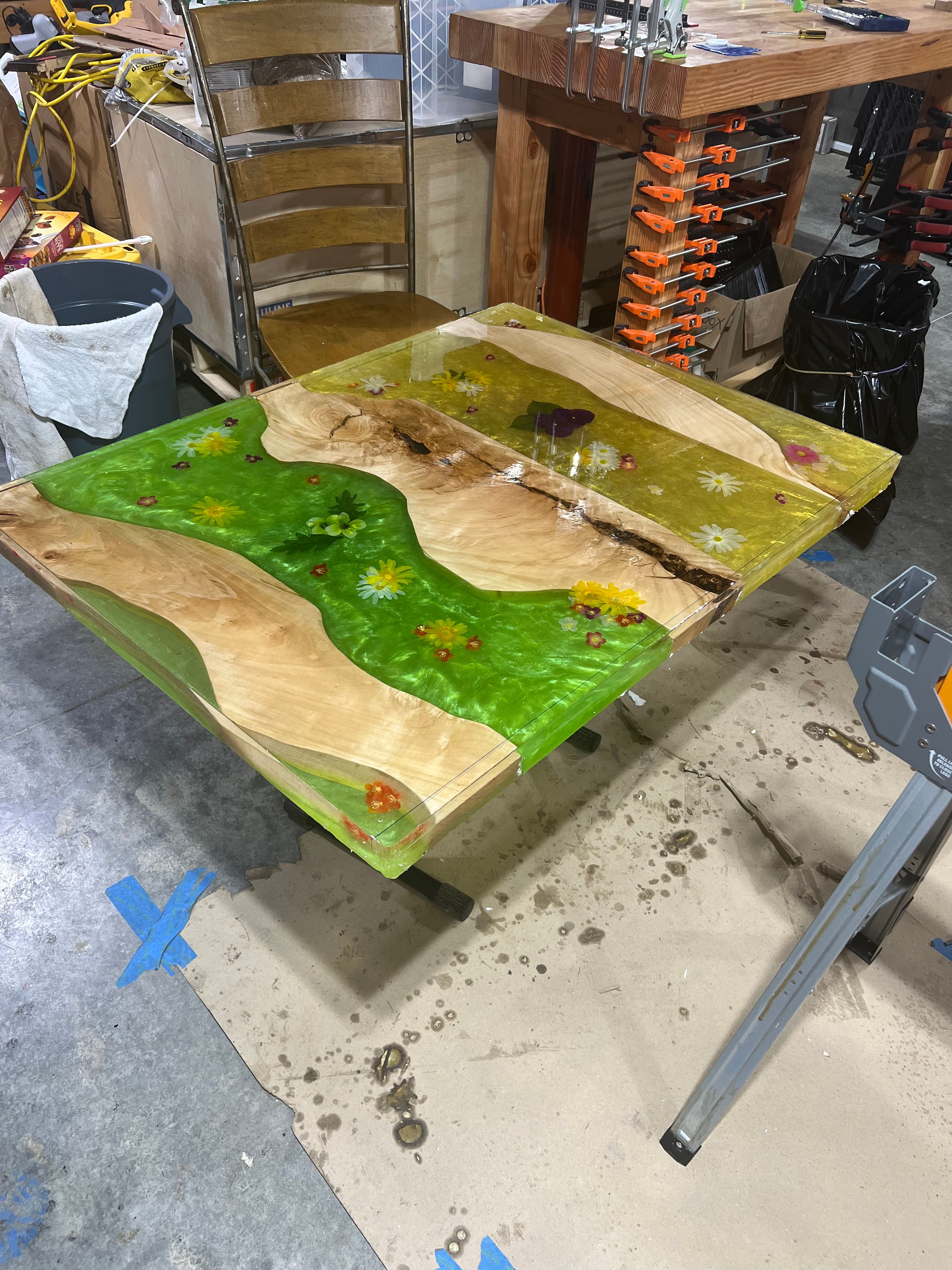 Resin table with embedded flowers in workshop setting
