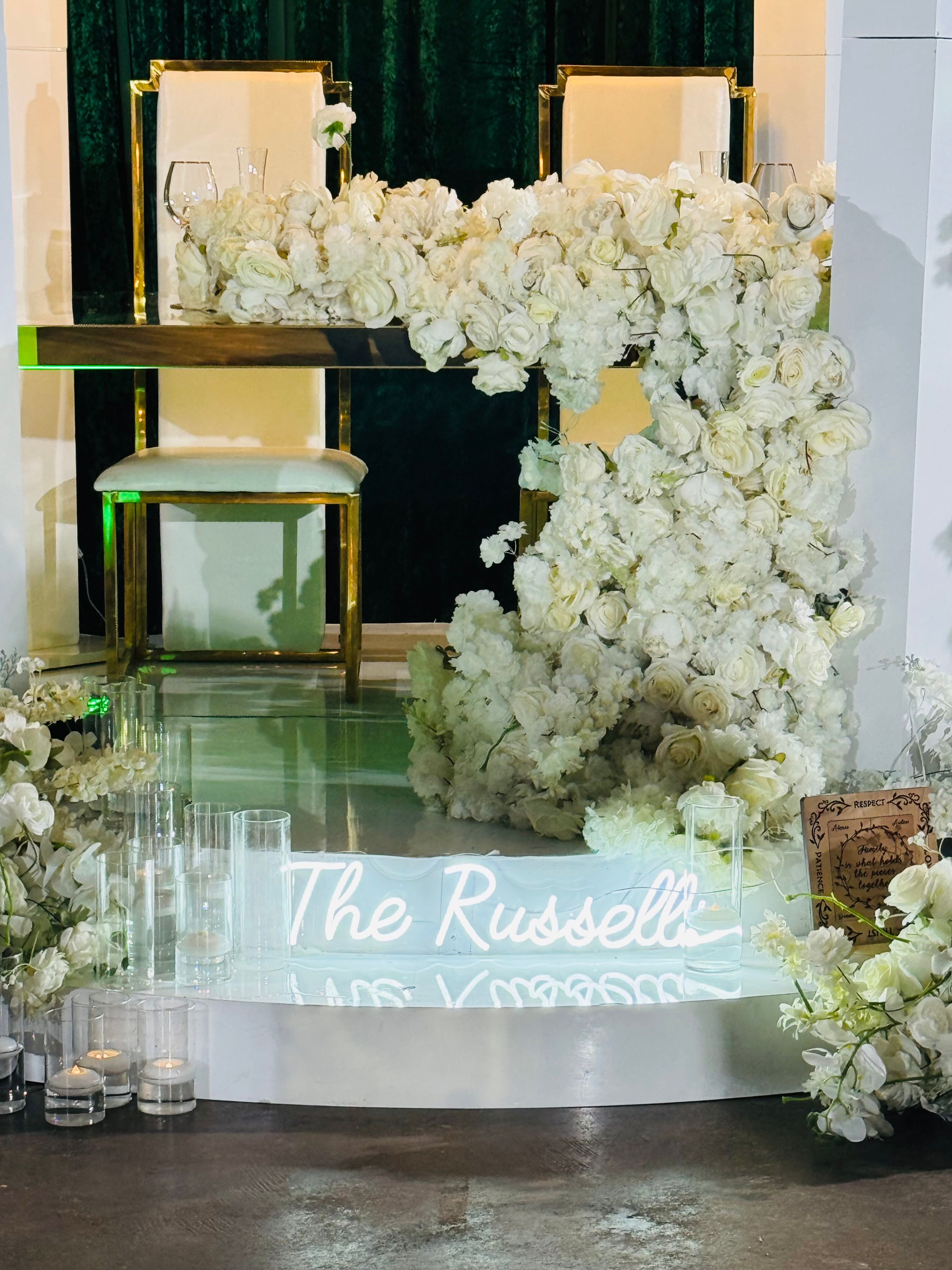 White floral wall backdrop with gold mirrors