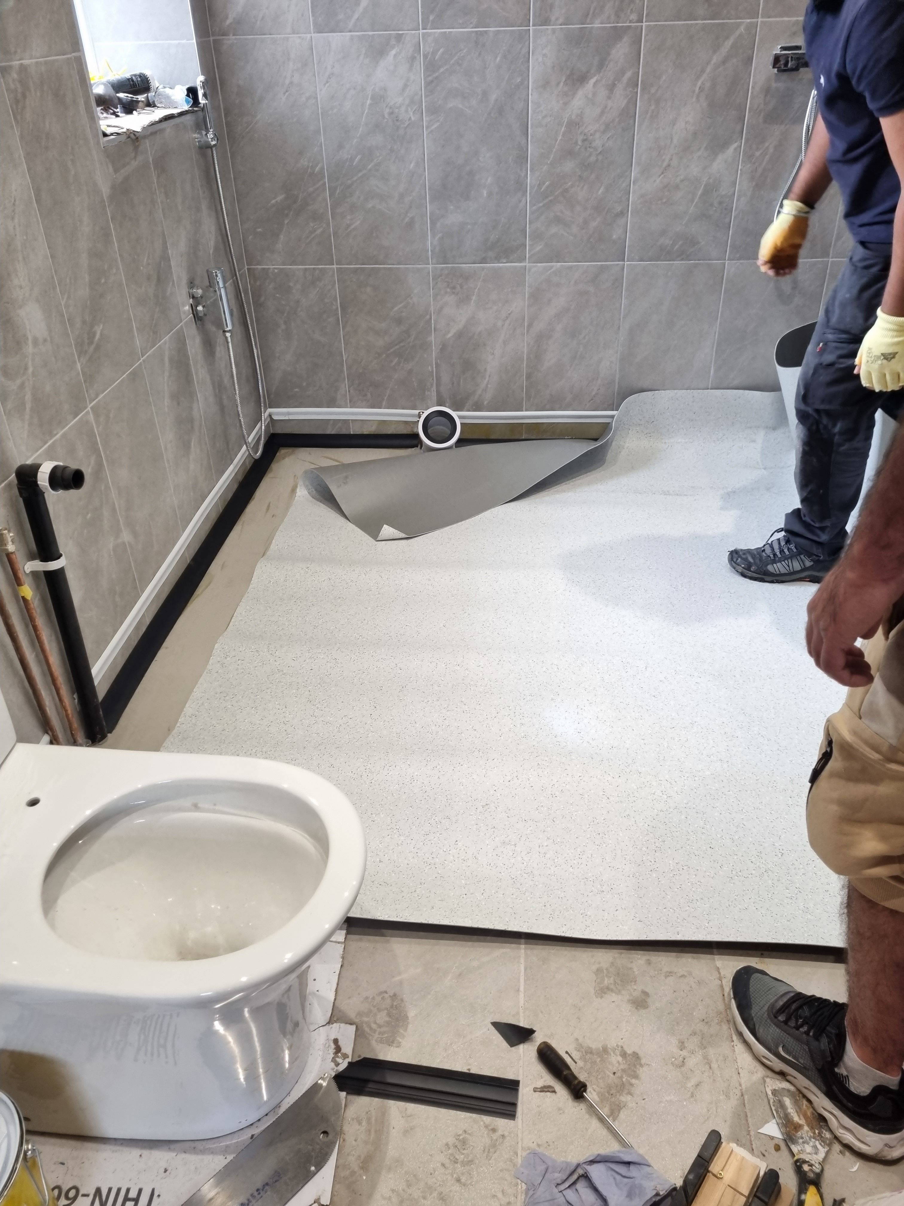 Team fitting vinyl in bathroom
