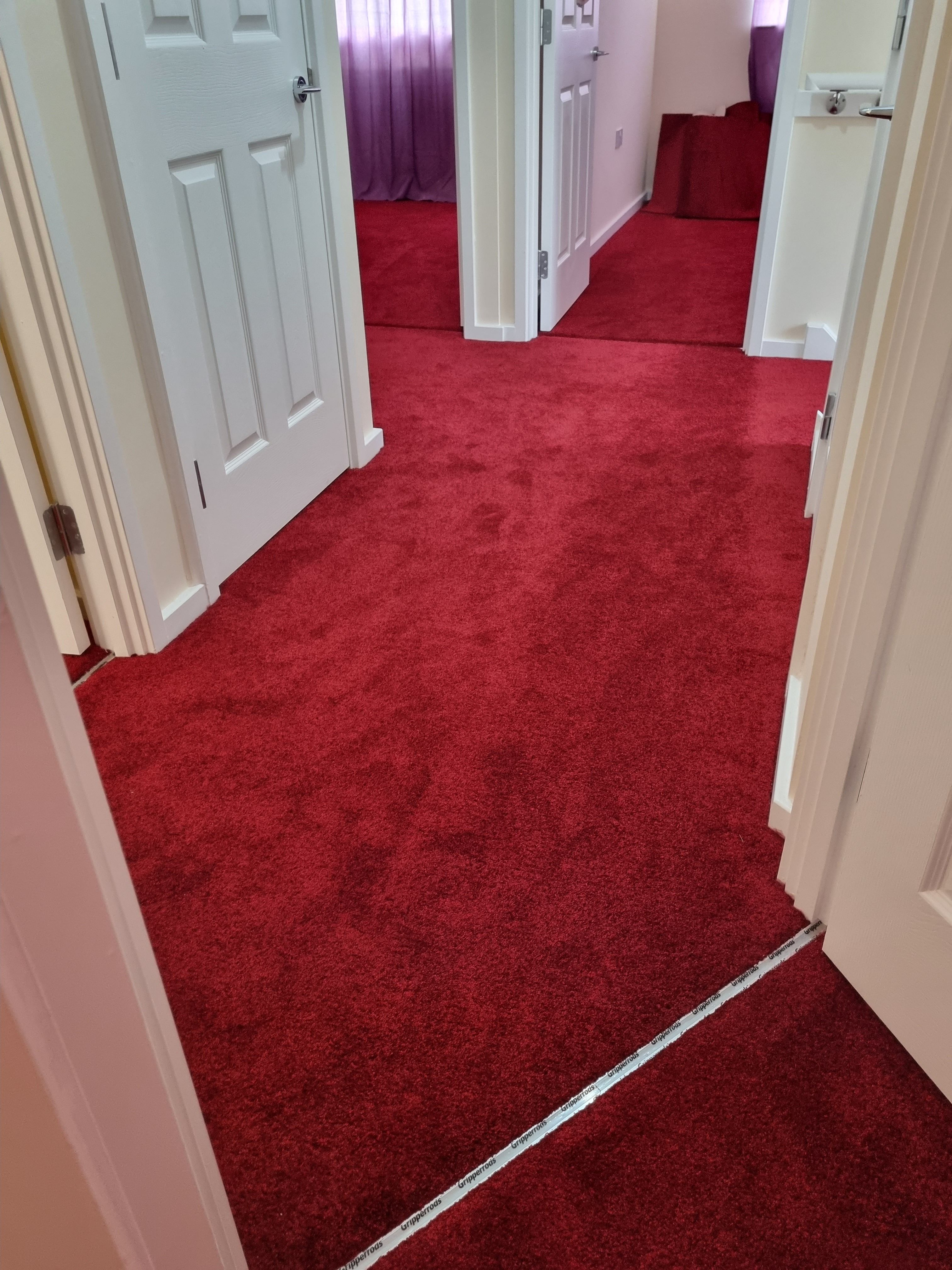 Bright red carpet fitted throughout hallway and rooms