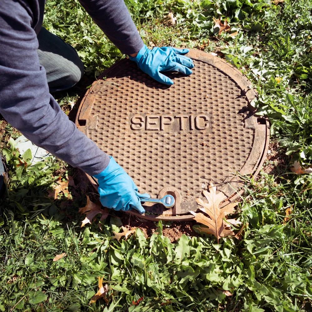 Technician working on septic tank cover