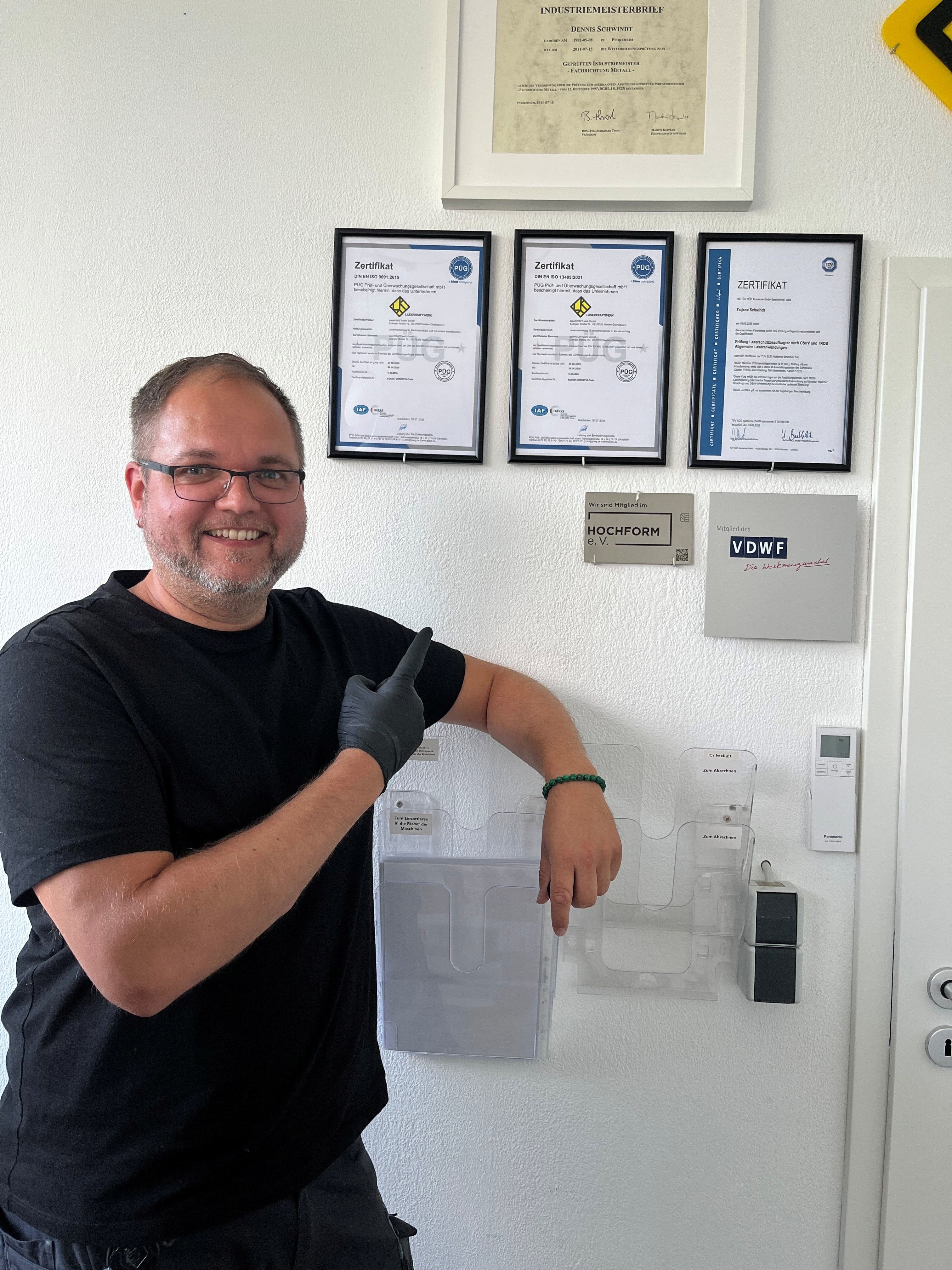 Dennis Schwindt vor der Zertifikatwand – ISO 9001 & ISO 13485 Re-Zertifizierung bei laserKRAFTwerk