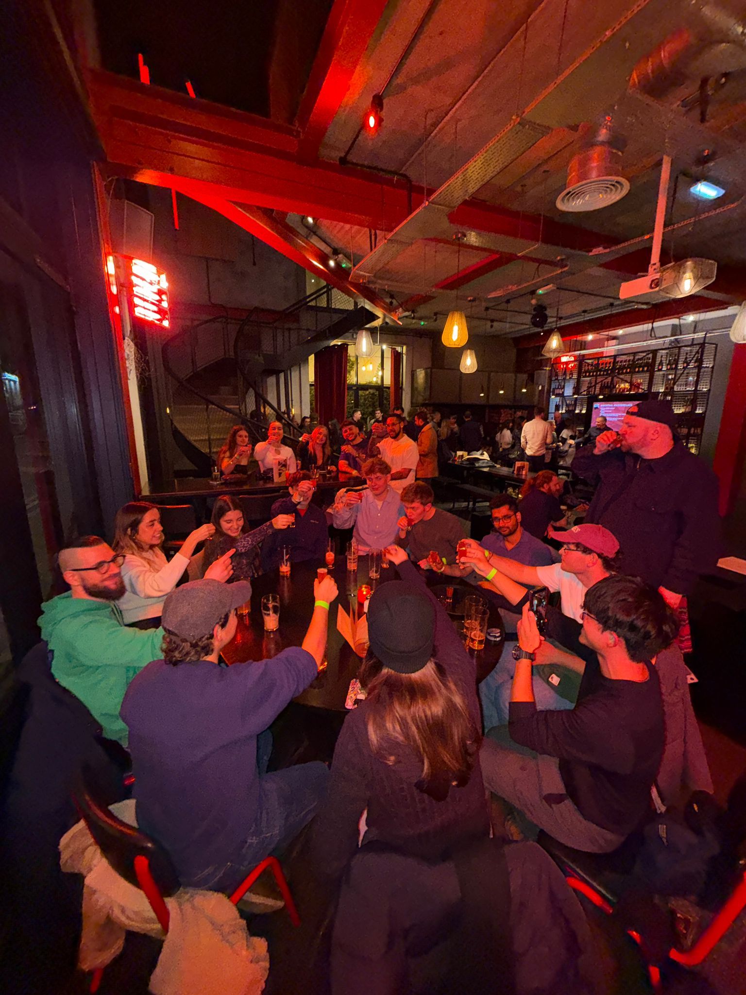Ebrius Glasgow pub crawl group raising glasses in a toast at a Glasgow bar on a Friday night