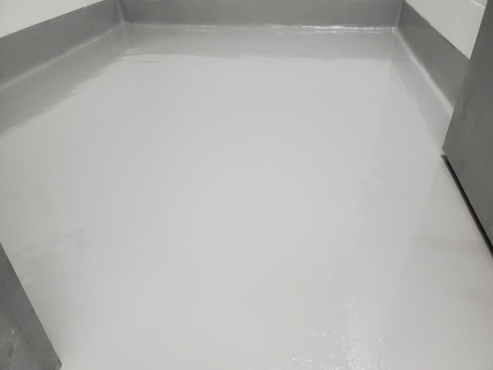Seamless white epoxy floor corner with matching baseboards in food and beverage facility