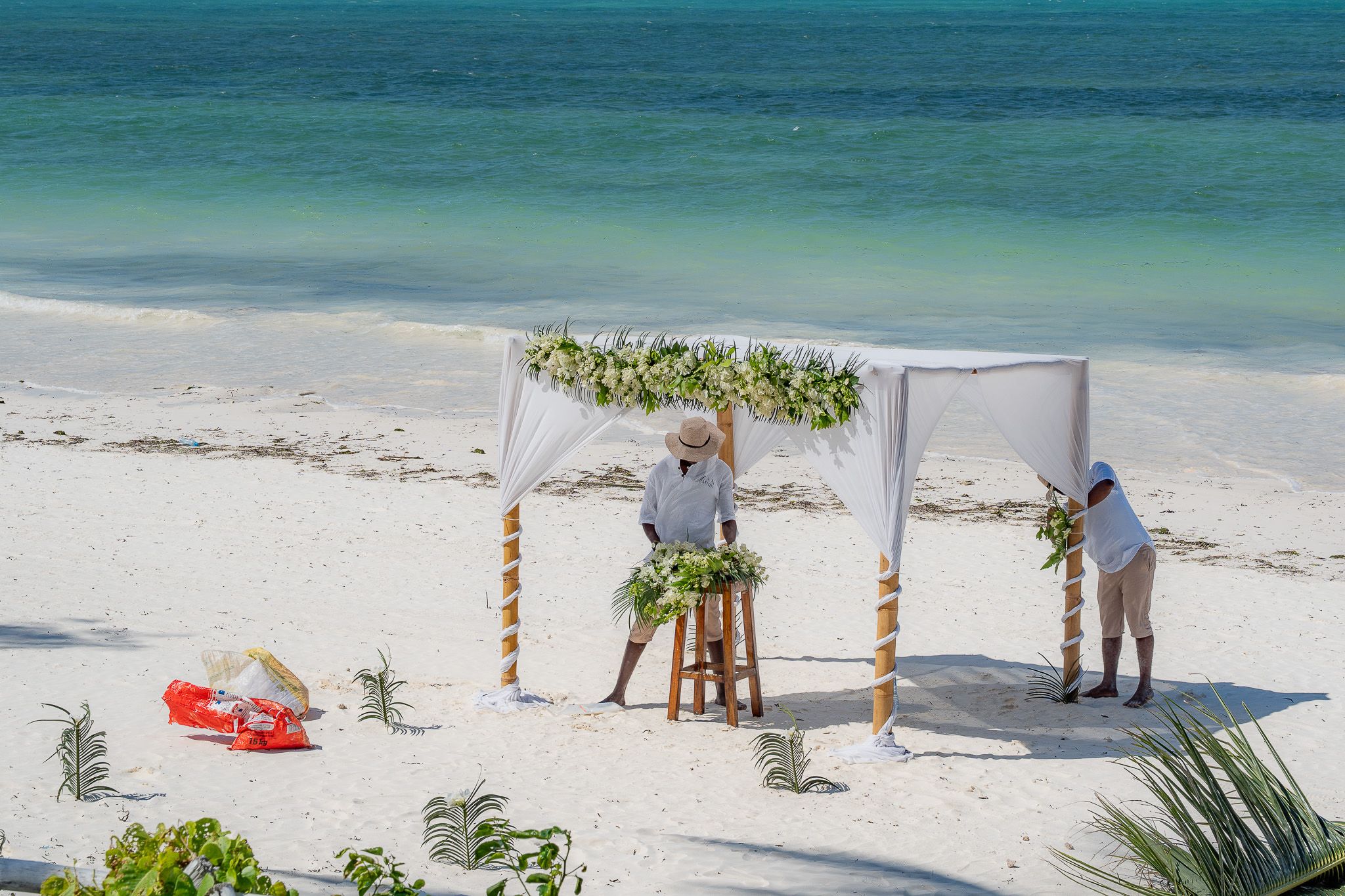 Decorating the ceremony arch with fresh tropical flowers