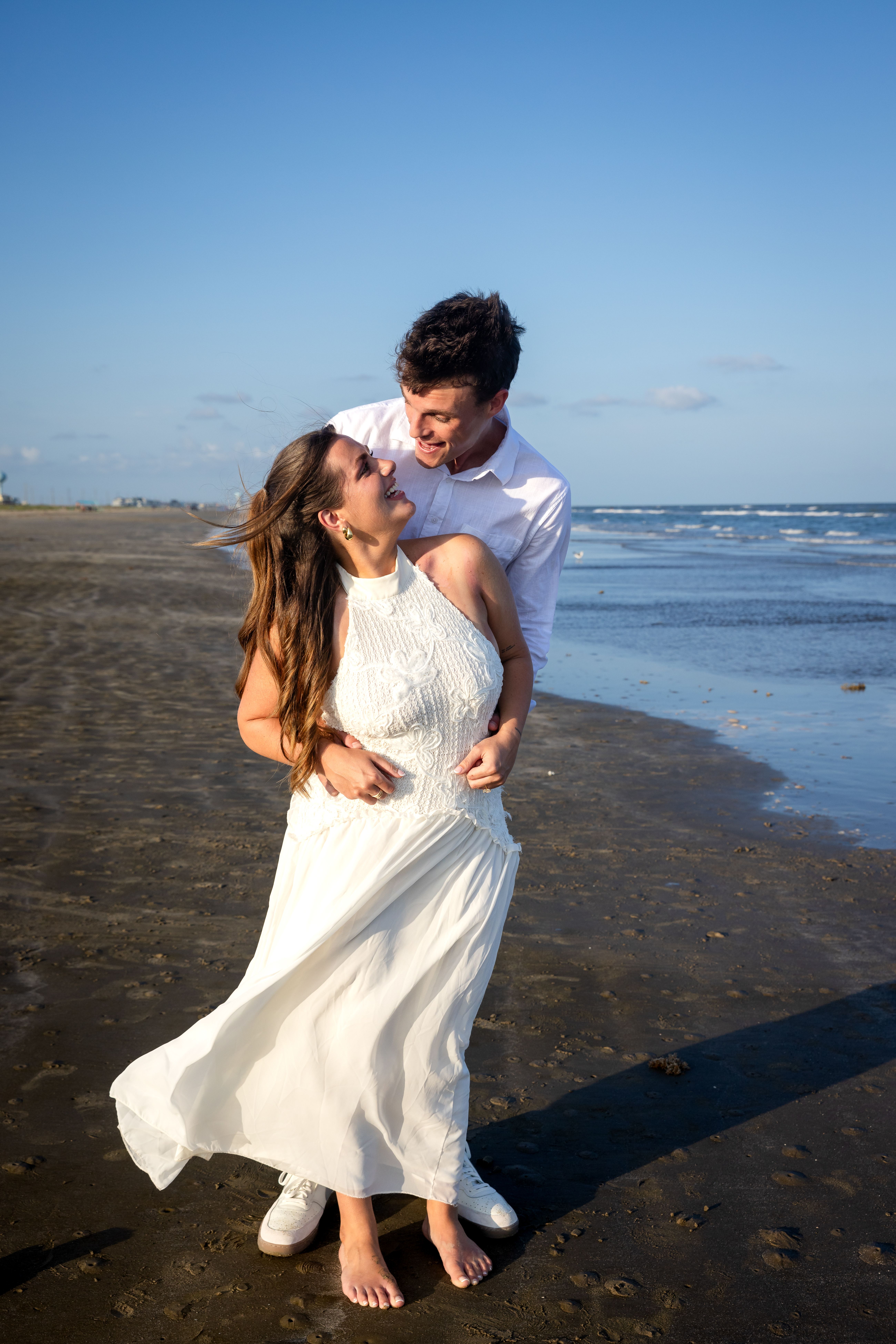 Smiling couple on the beach at the water's edge