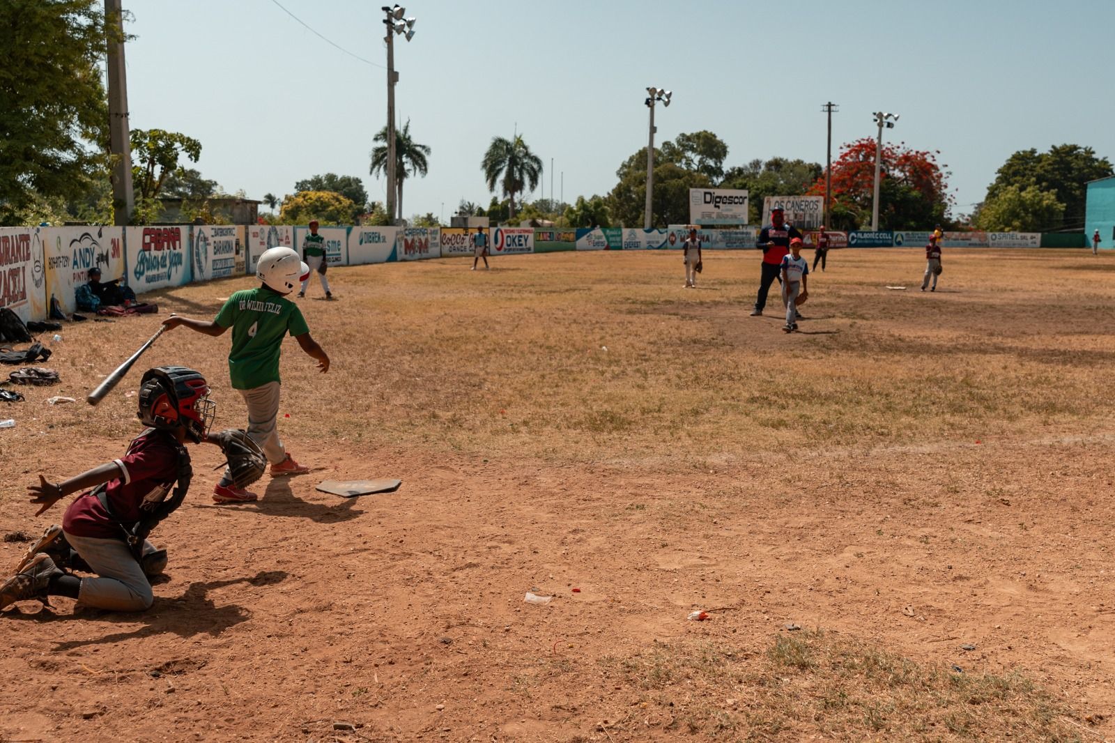 Youth baseball game in progress on a Dominican field