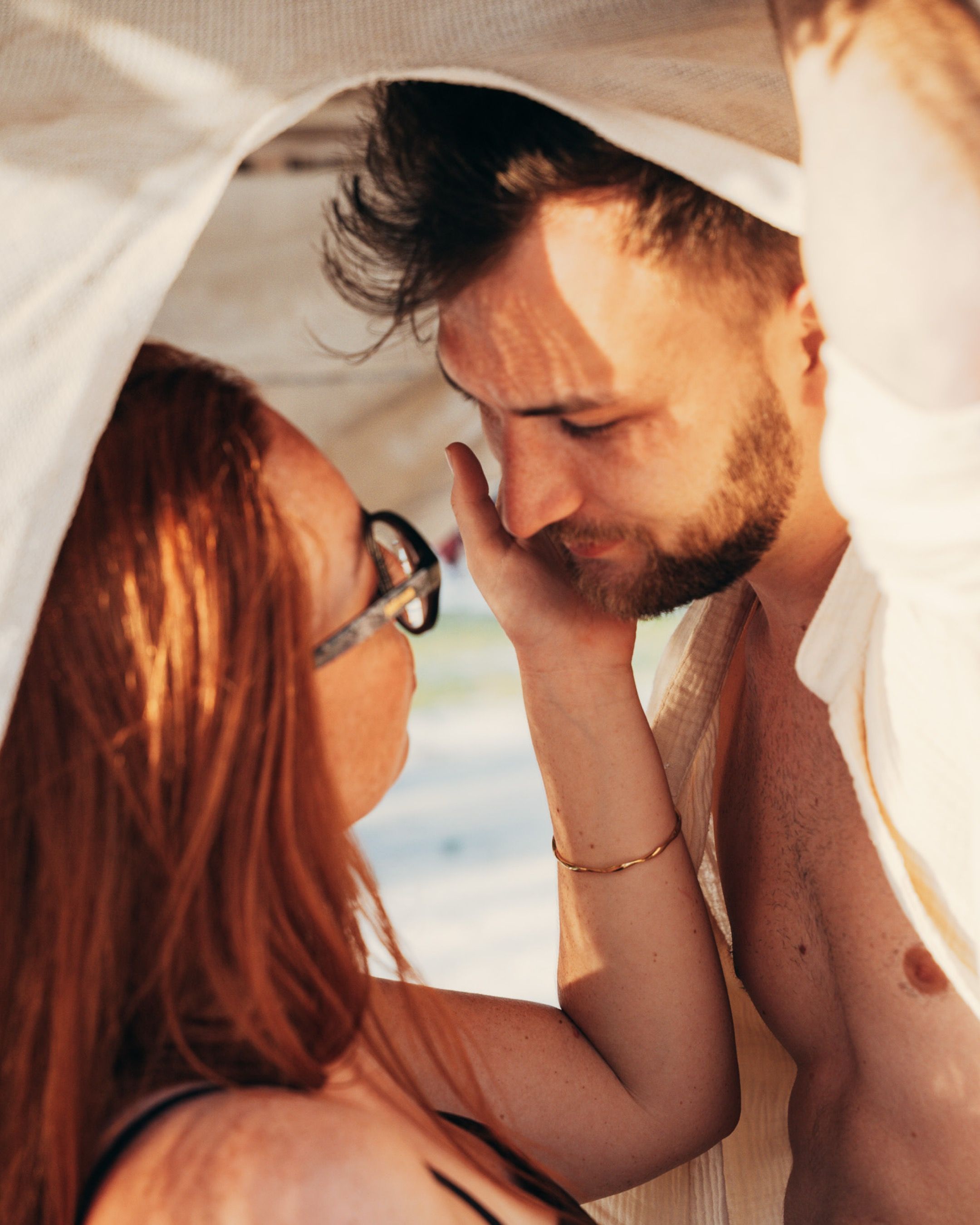 Honeymoon couple under white fabric