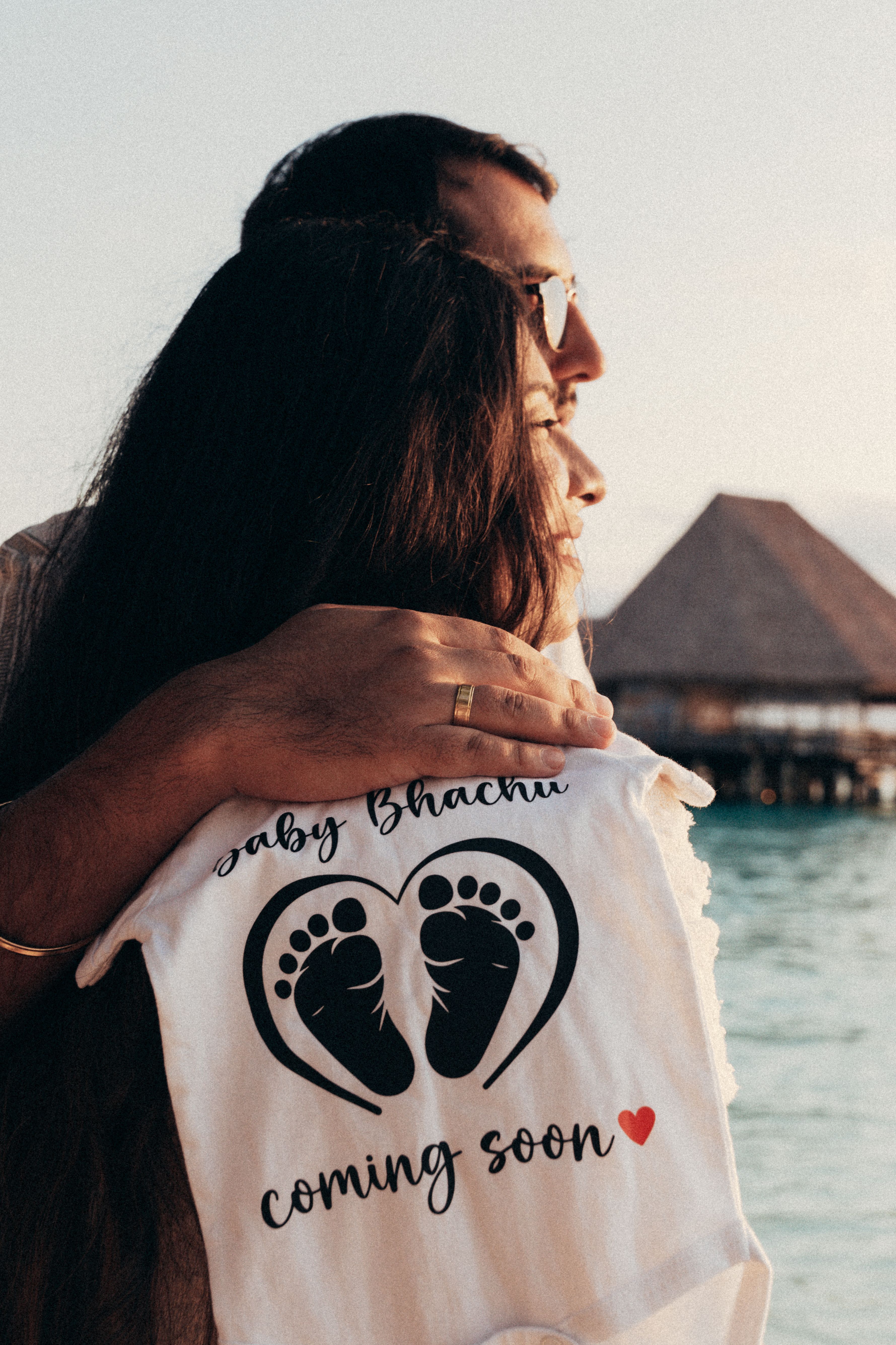 Couple embracing with Baby coming soon announcement - pregnancy reveal Zanzibar