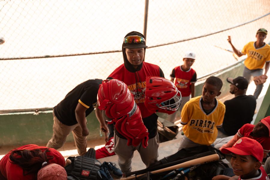 Empower Baseball team sitting in the dugout with their coach before a game