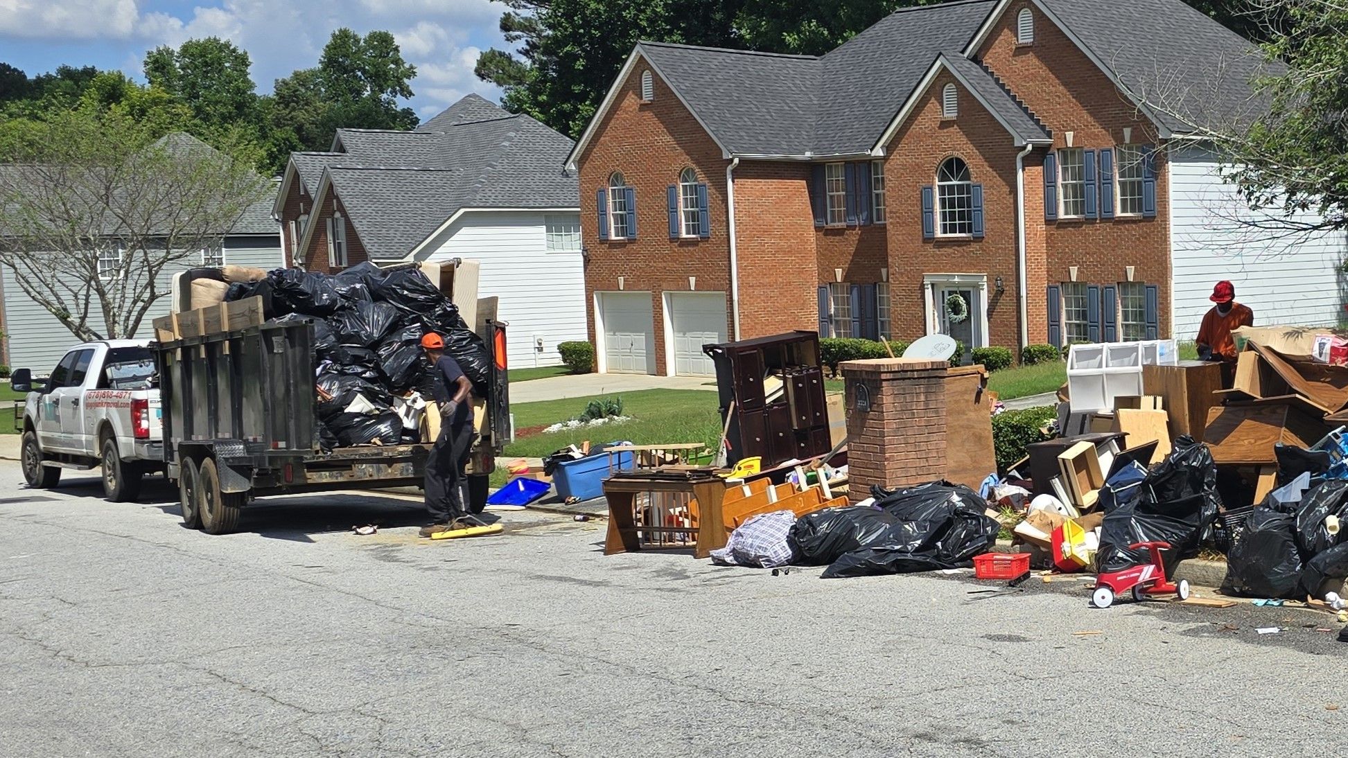 Residential junk removal - GoGo Junk Removal team at curbside pickup loading furniture and household debris