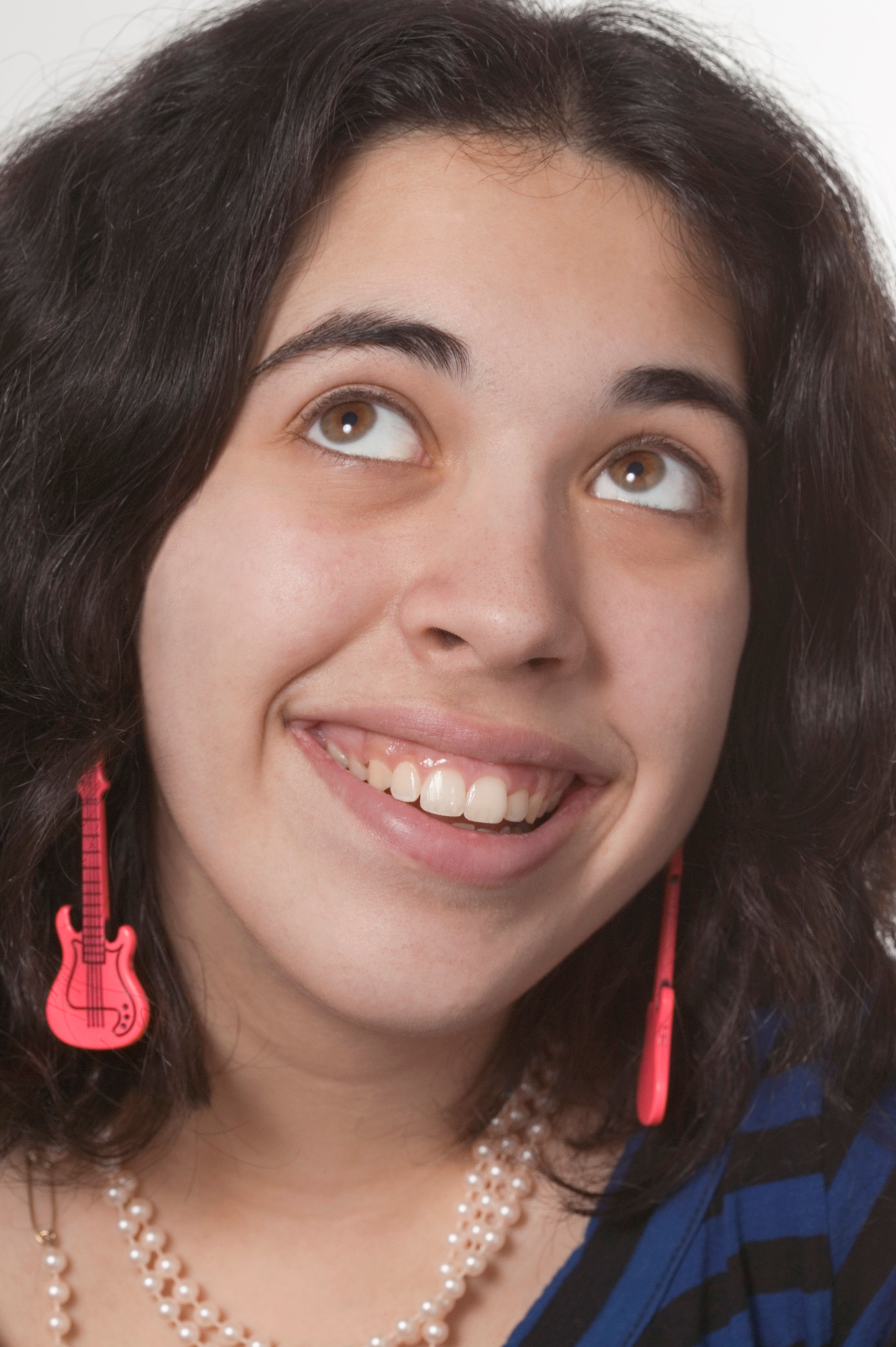 Smiling young woman with guitar earrings
