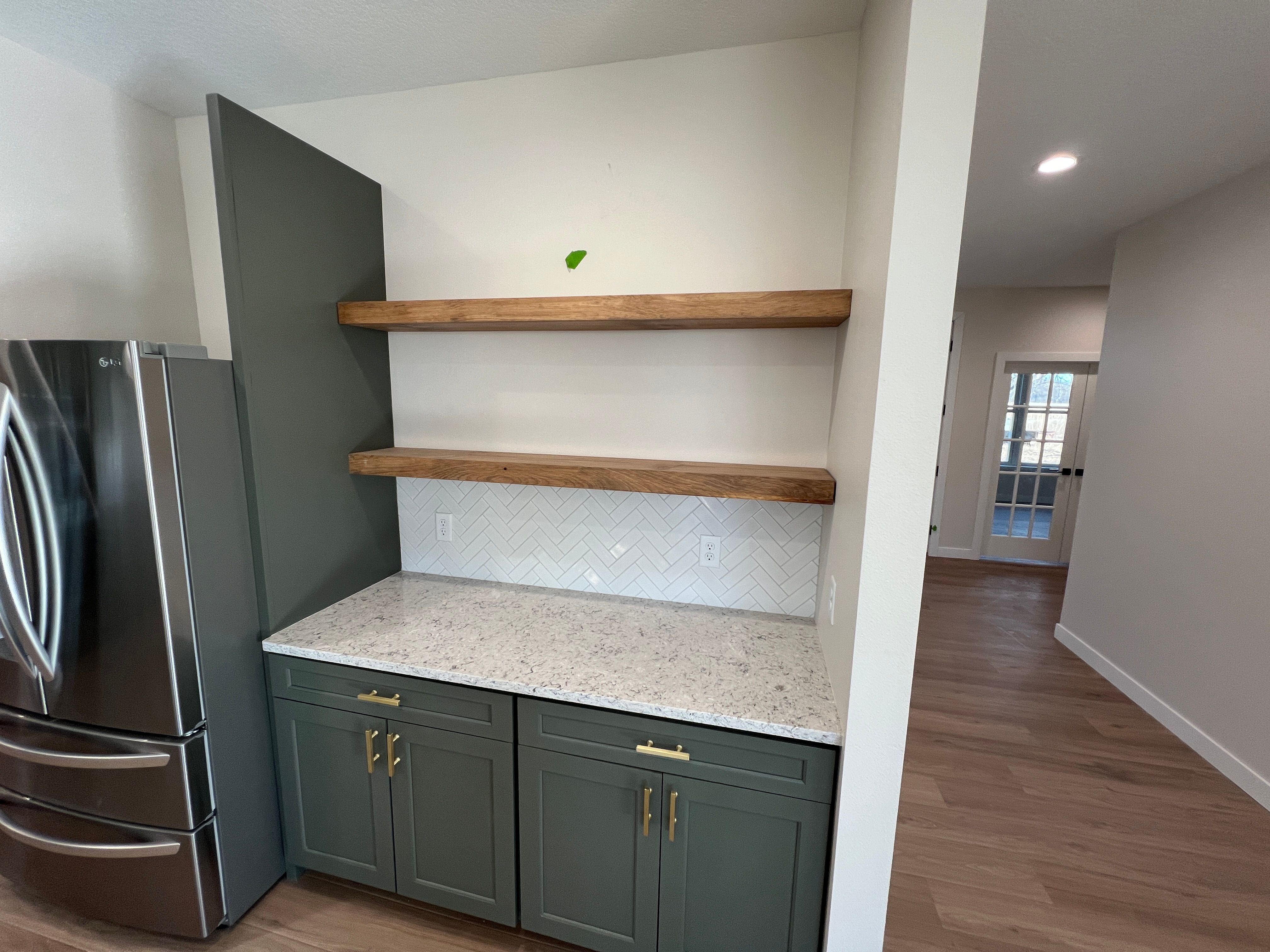 Custom kitchen design with green cabinets and herringbone backsplash