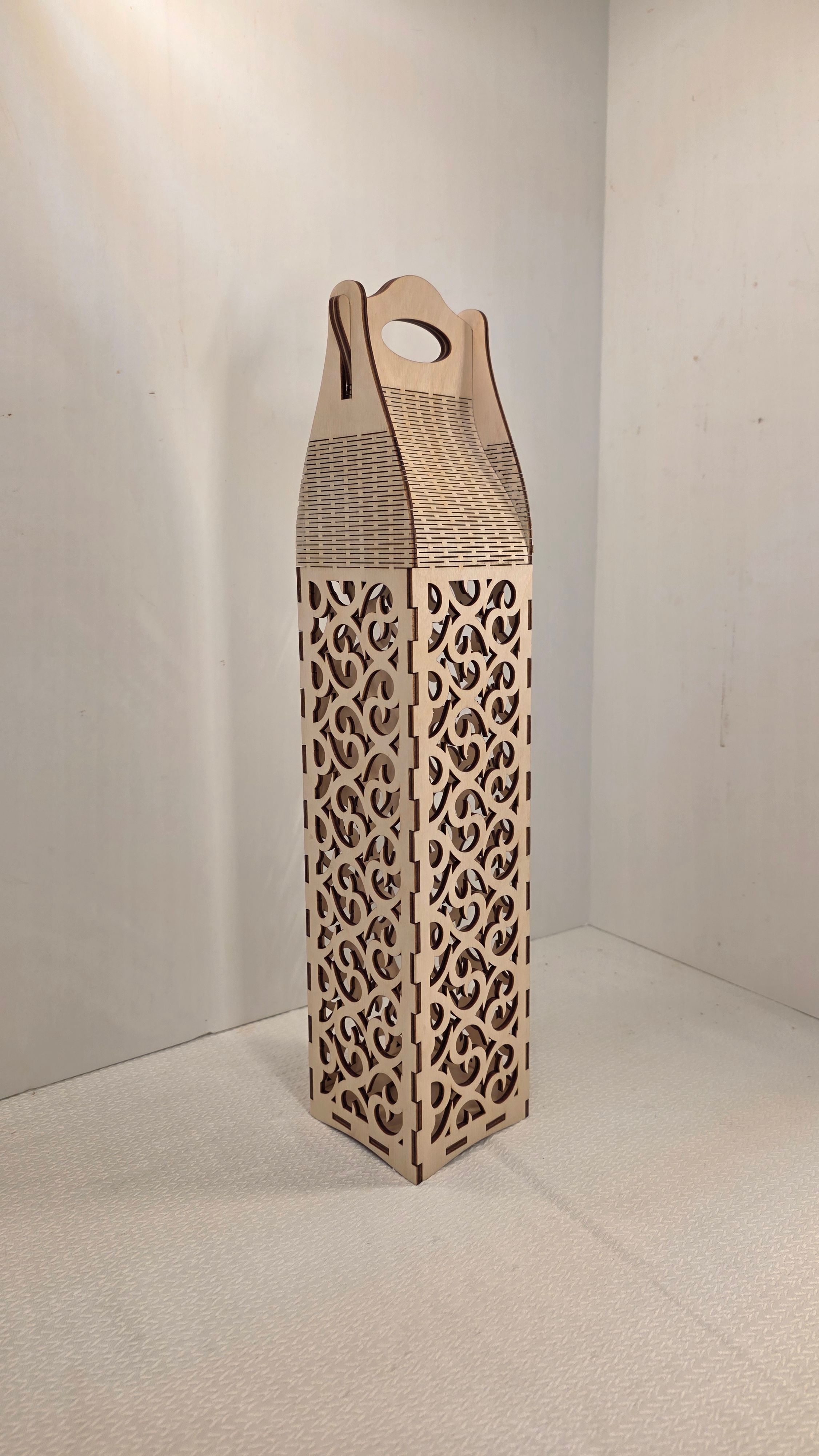 Tall wooden wine box with intricate cut-out patterns