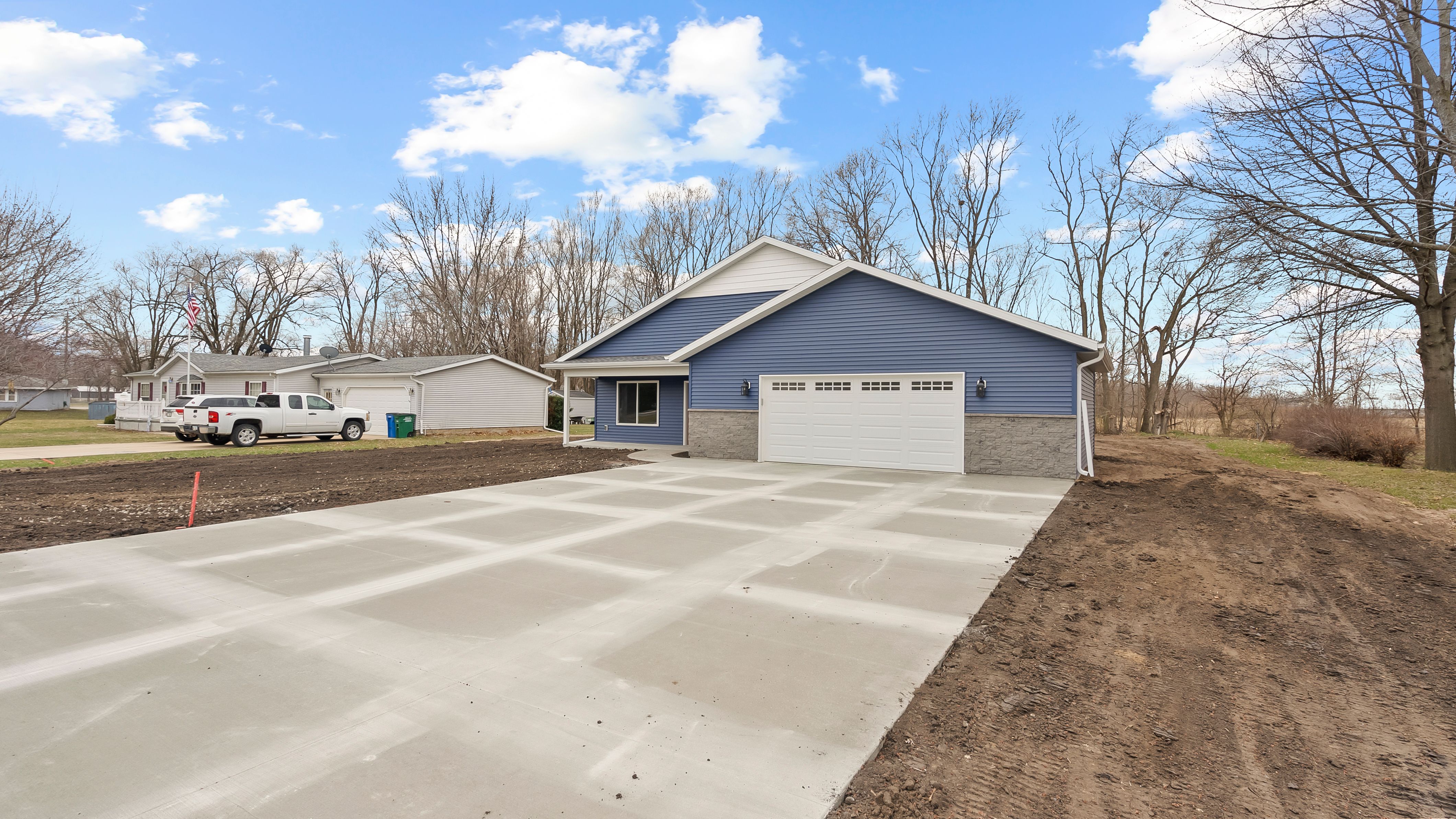 Completed custom ranch home with blue siding by Newhoff Construction