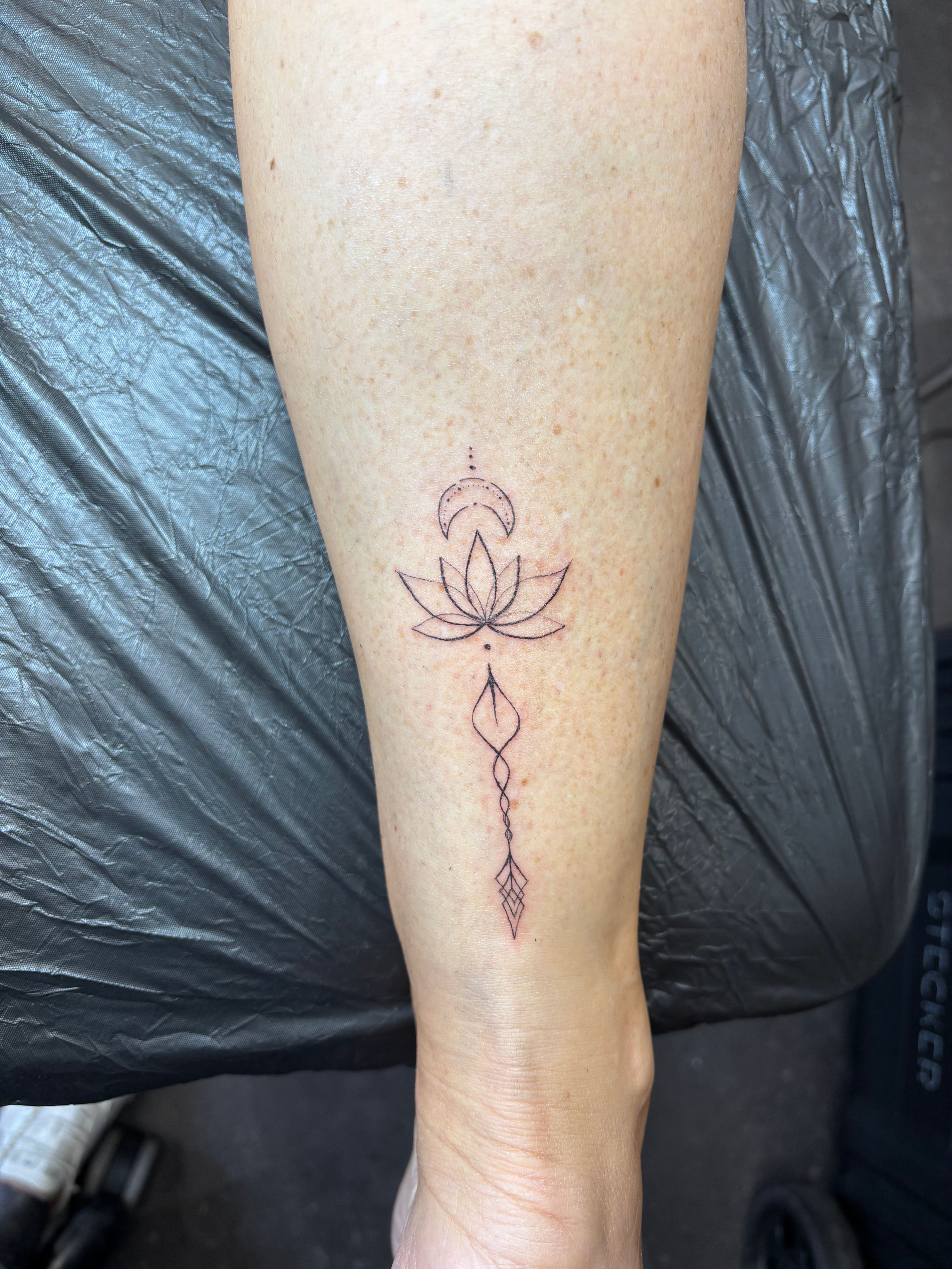 Maan en lotus met geometrische lijnen op het onderbeen