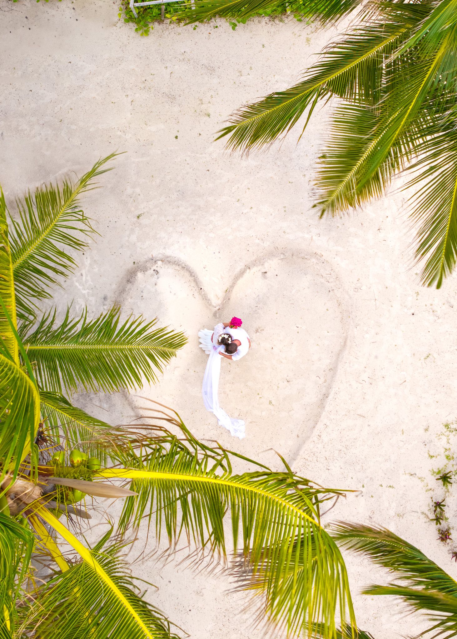 Aerial drone shot of couple in heart shape on sand
