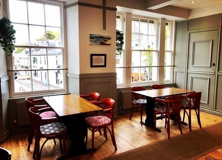 The Castle Tavern cosy dining room with red chairs and natural light