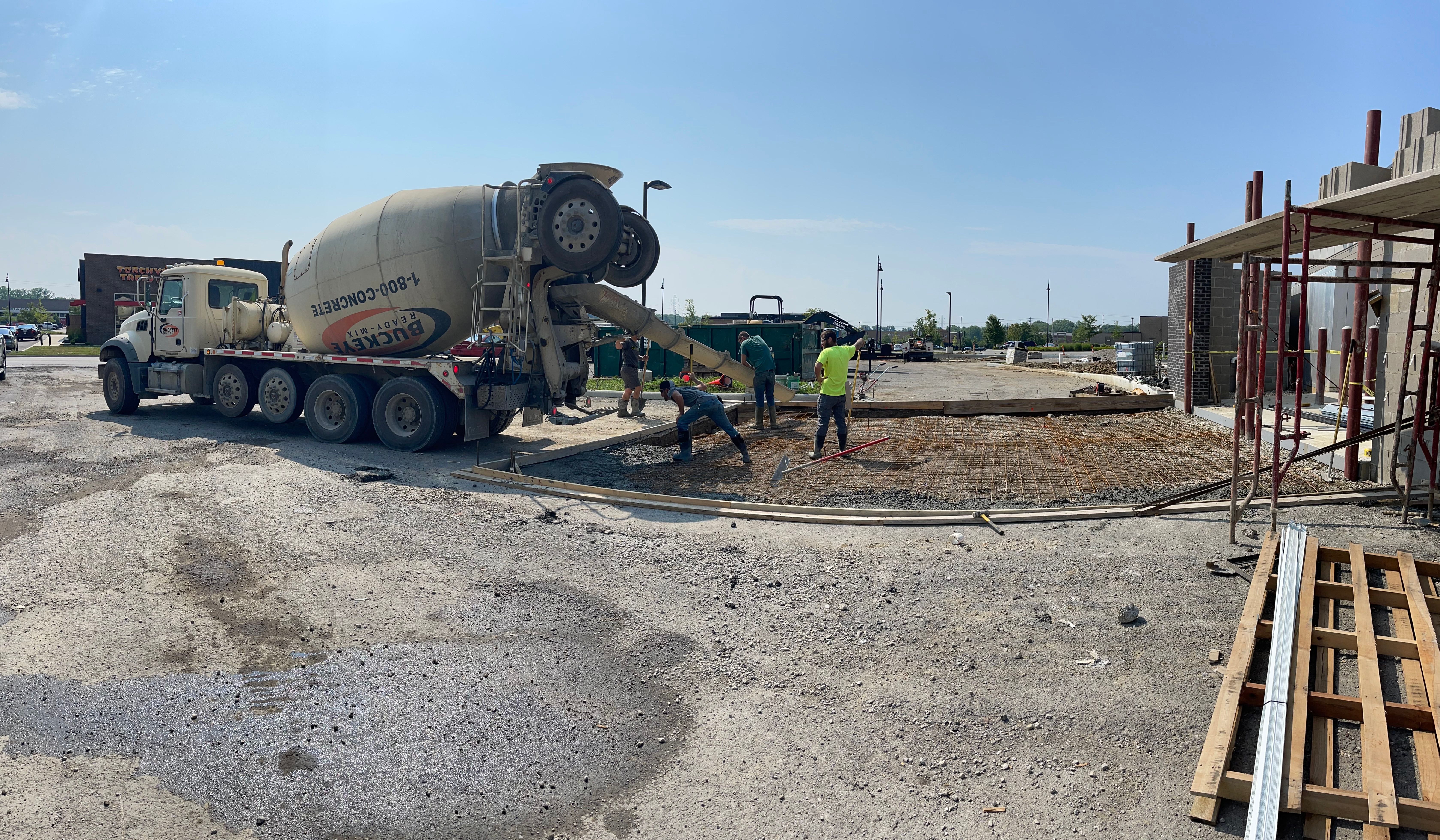 Concrete mixer truck on site with crew spreading slab in Central Ohio