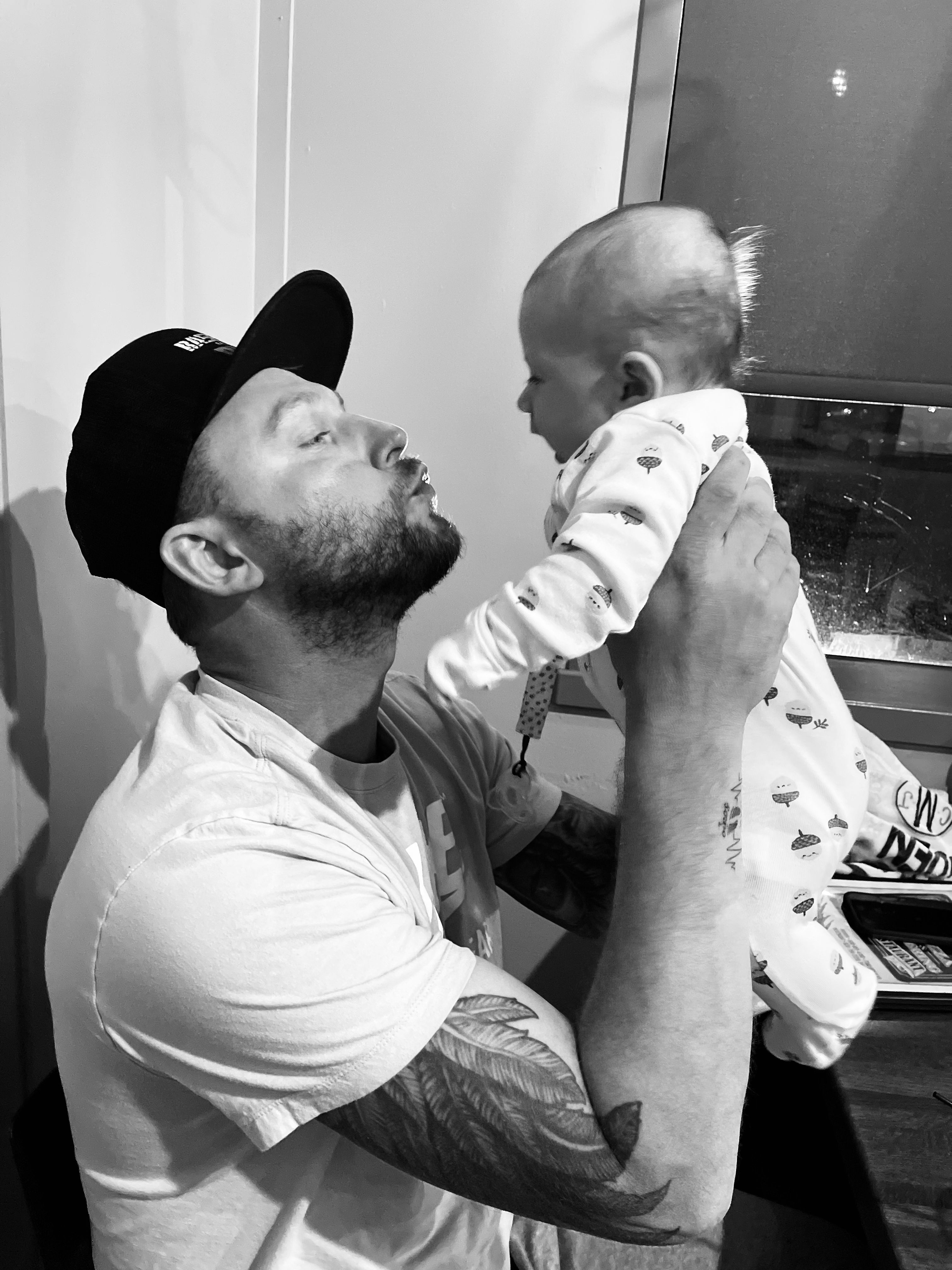 Derrick Molski - Owner of Pulse Exterior - holding his son