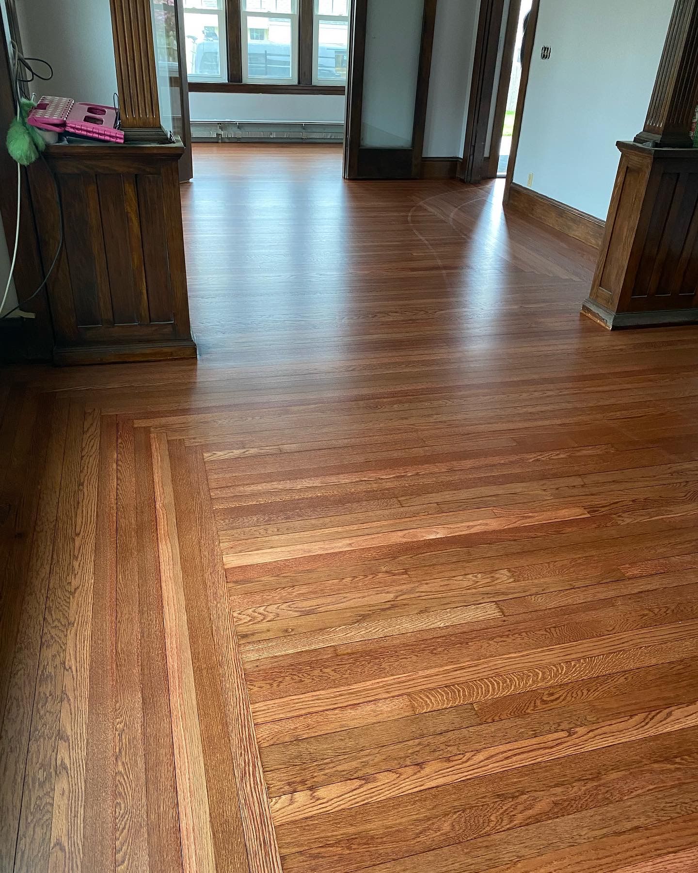 Polished hardwood floors in upscale residential room with columns and windows