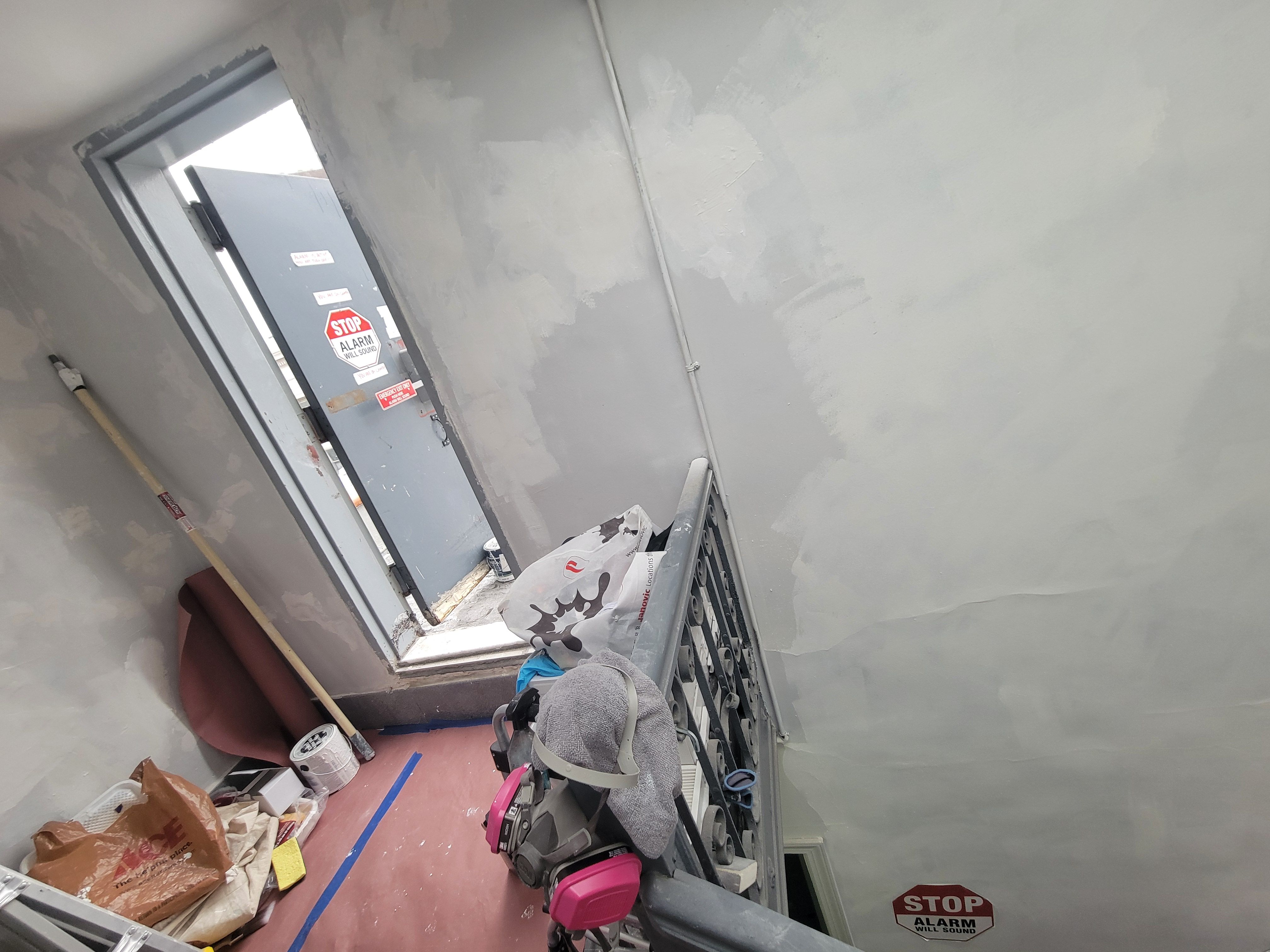 Roof landing stain killer application - door area with patched walls and protective covering