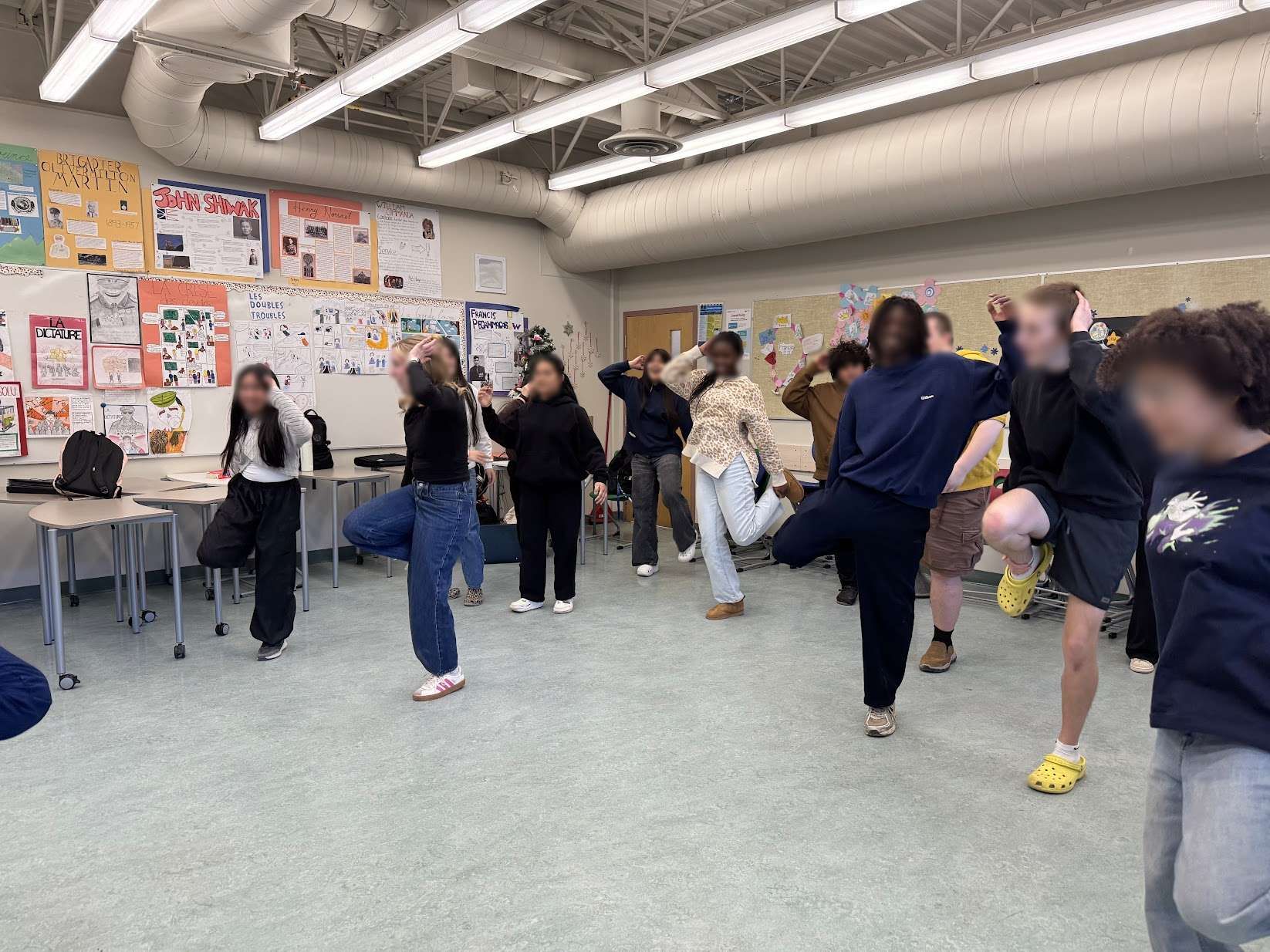 Students and facilitator posing together after a collective movement creation in a classroom