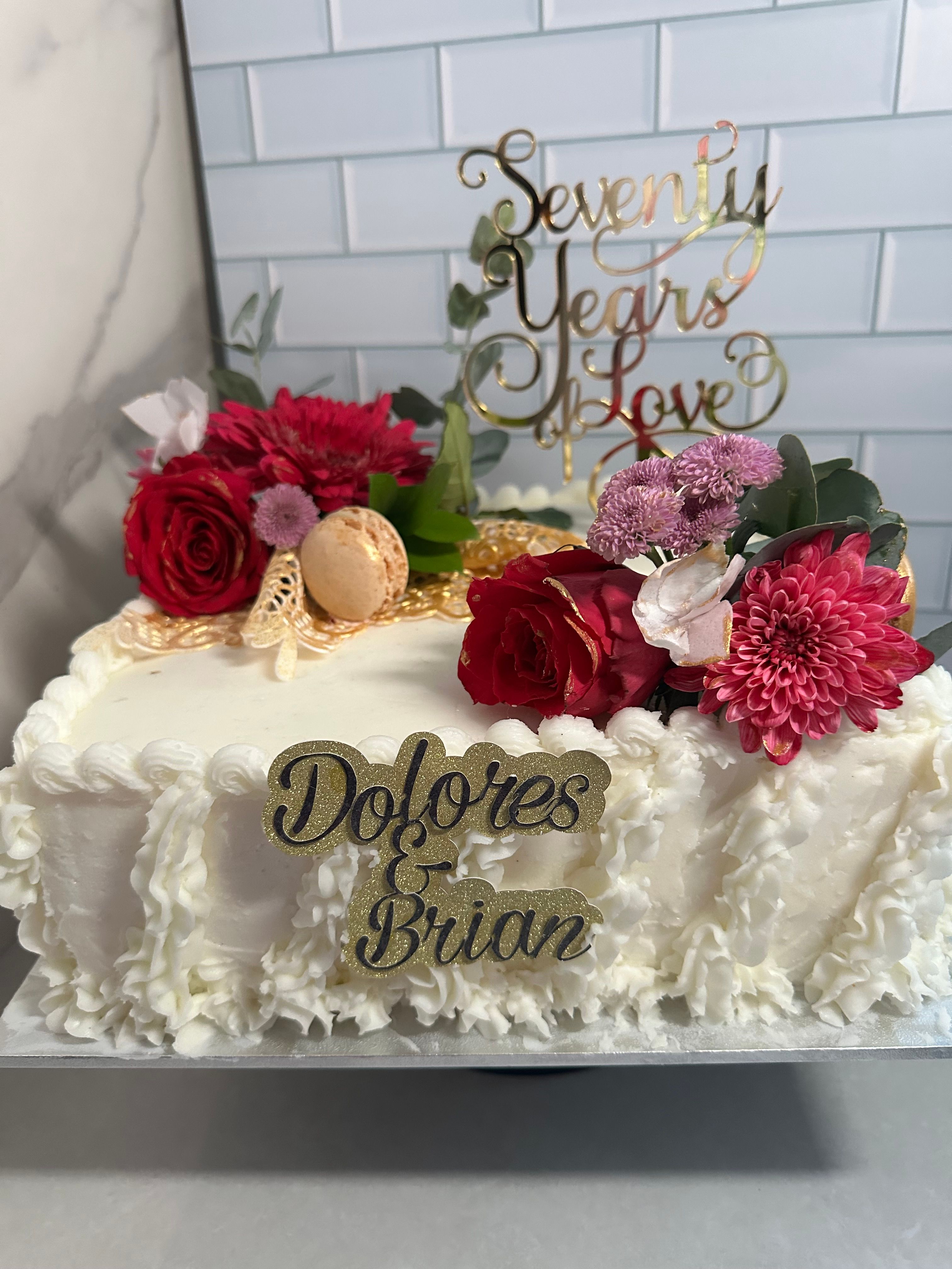 Anniversary cake with ruffled buttercream, florals and custom gold toppers
