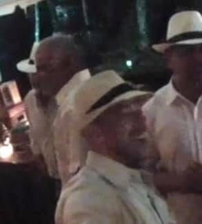 Three men in white guayabera shirts and Panama hats — the 1950s Caribbean look