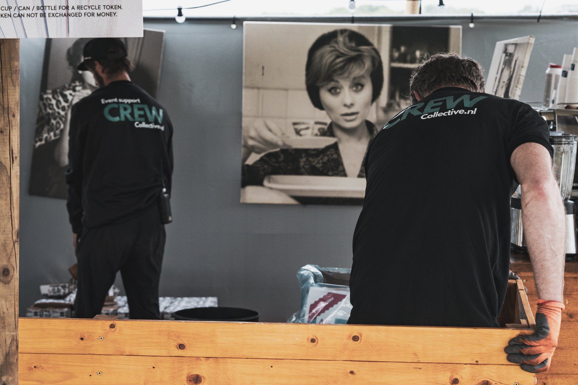 Teamleider geeft instructies aan crewleden op een evenementlocatie met materiaal op de achtergrond
