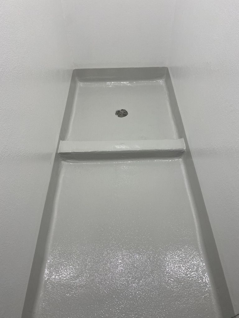 White seamless epoxy wet area floor with integrated drain cover and coved walls in a pharmaceutical facility