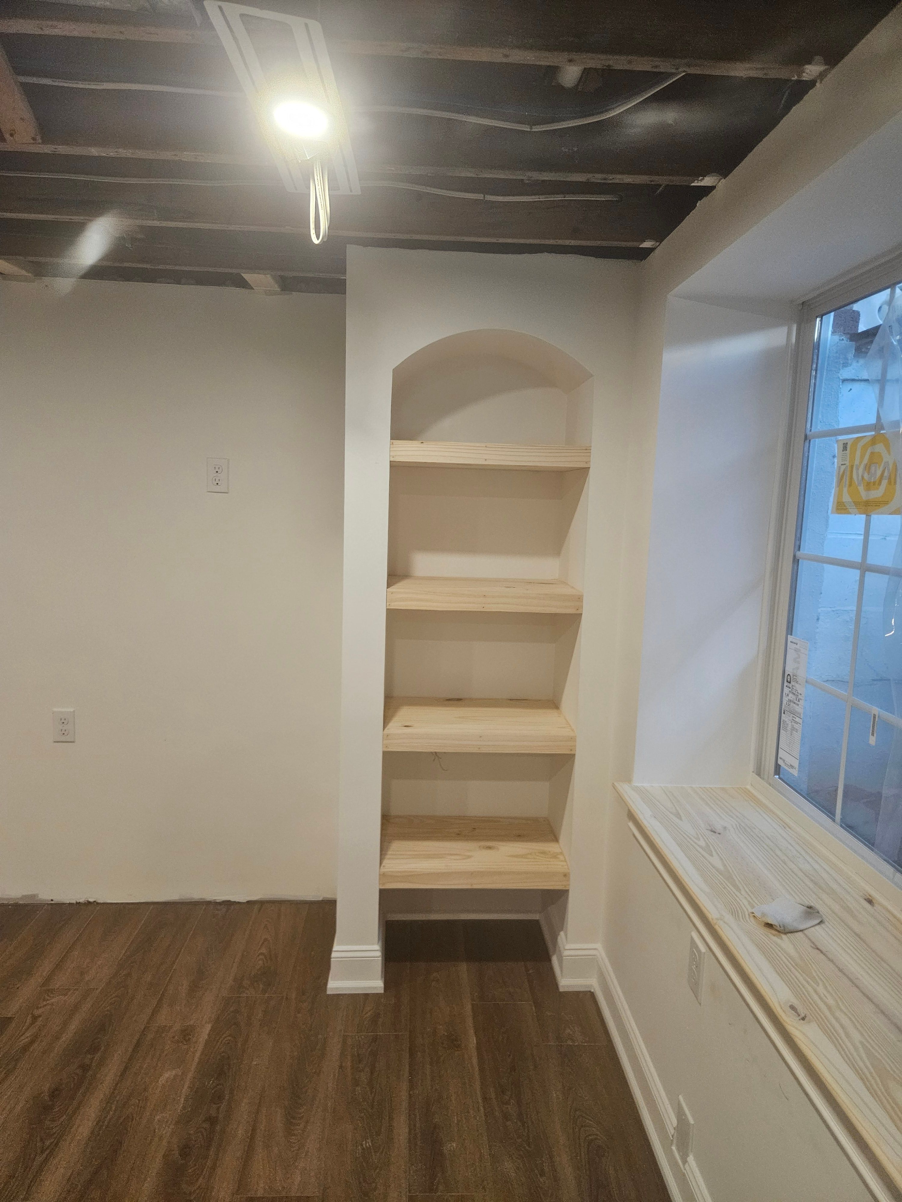 Built-in shelving with arched detail in finished basement