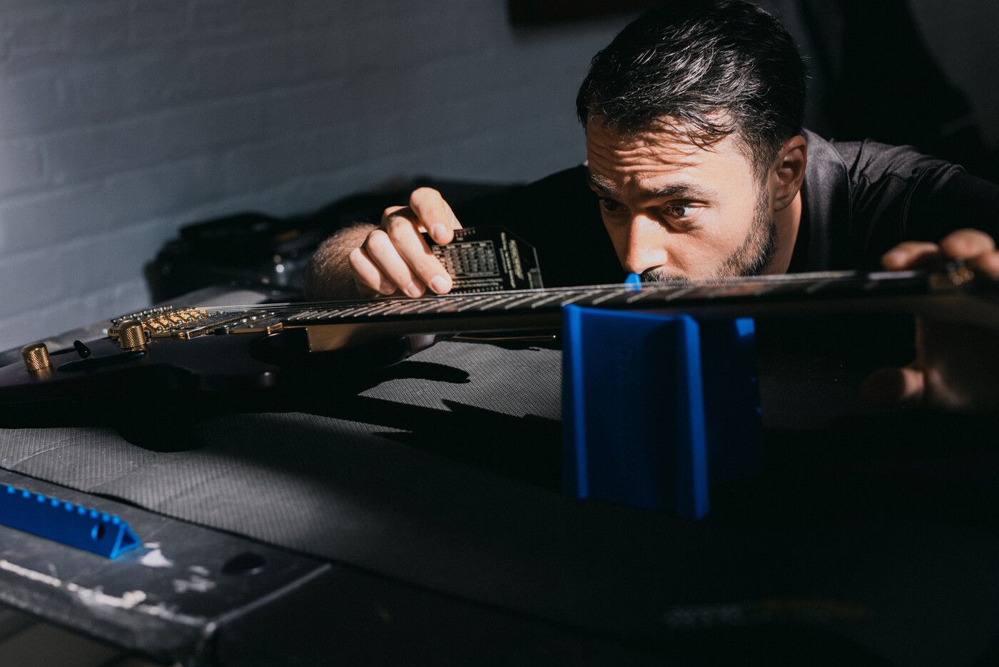 Tyler performing a guitar setup with precision tools