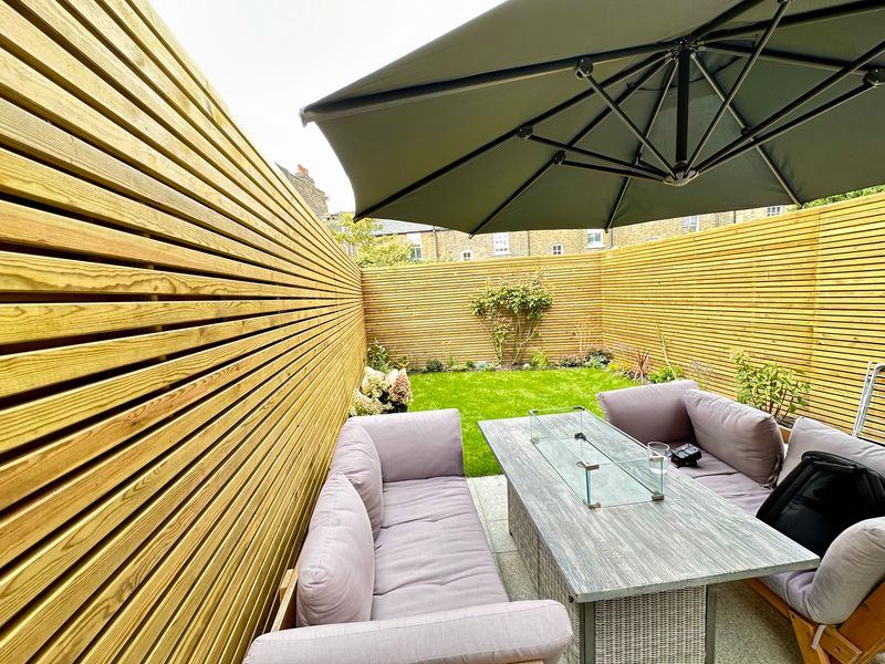 Bespoke patio installation in Blackheath SE3 — rendered seating wall, ivory porcelain paving and LED step lighting by Wicked Gardens LTD