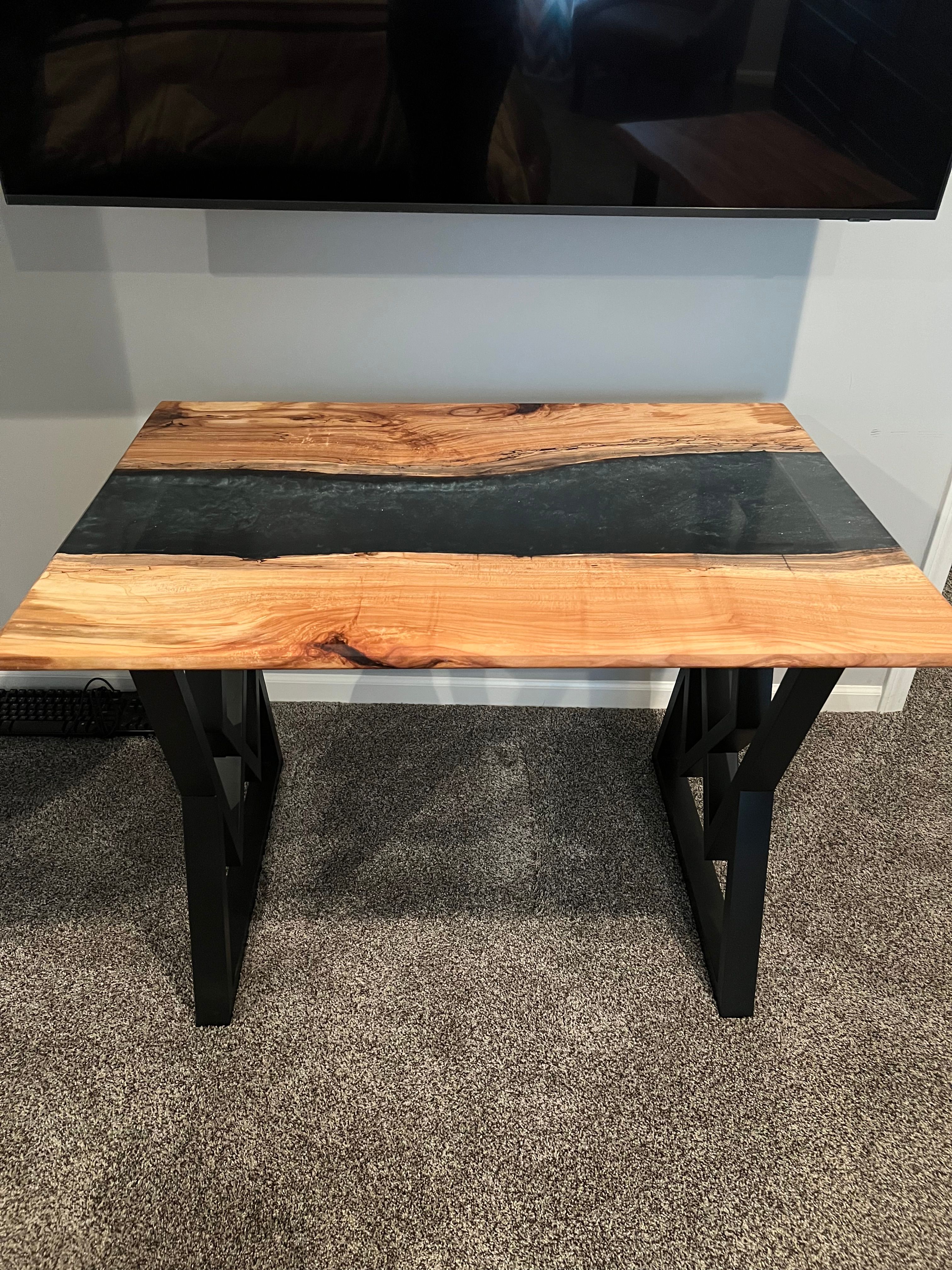 River table with black resin and geometric metal legs
