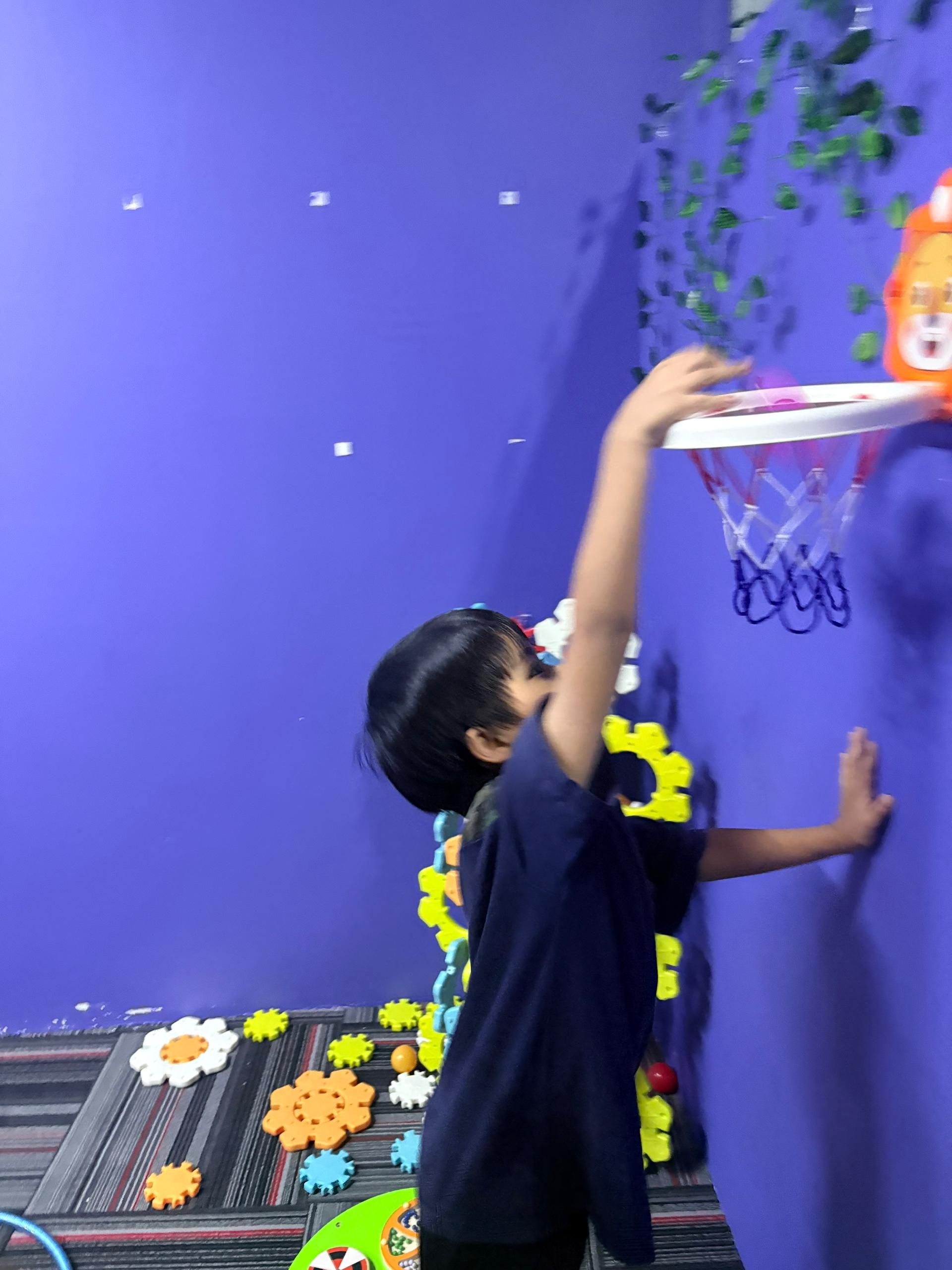 Child reaching for basketball hoop