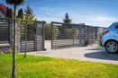 Residential sliding gate with automated motor installed on a concrete driveway