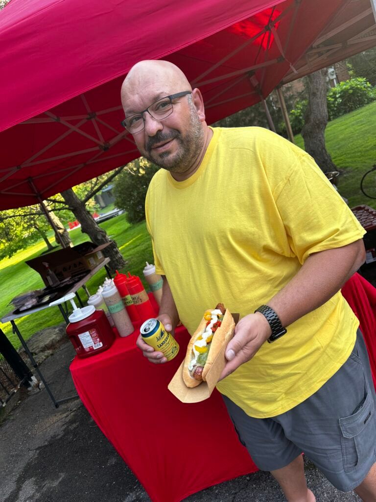 Customer showing off a loaded gourmet hot dog