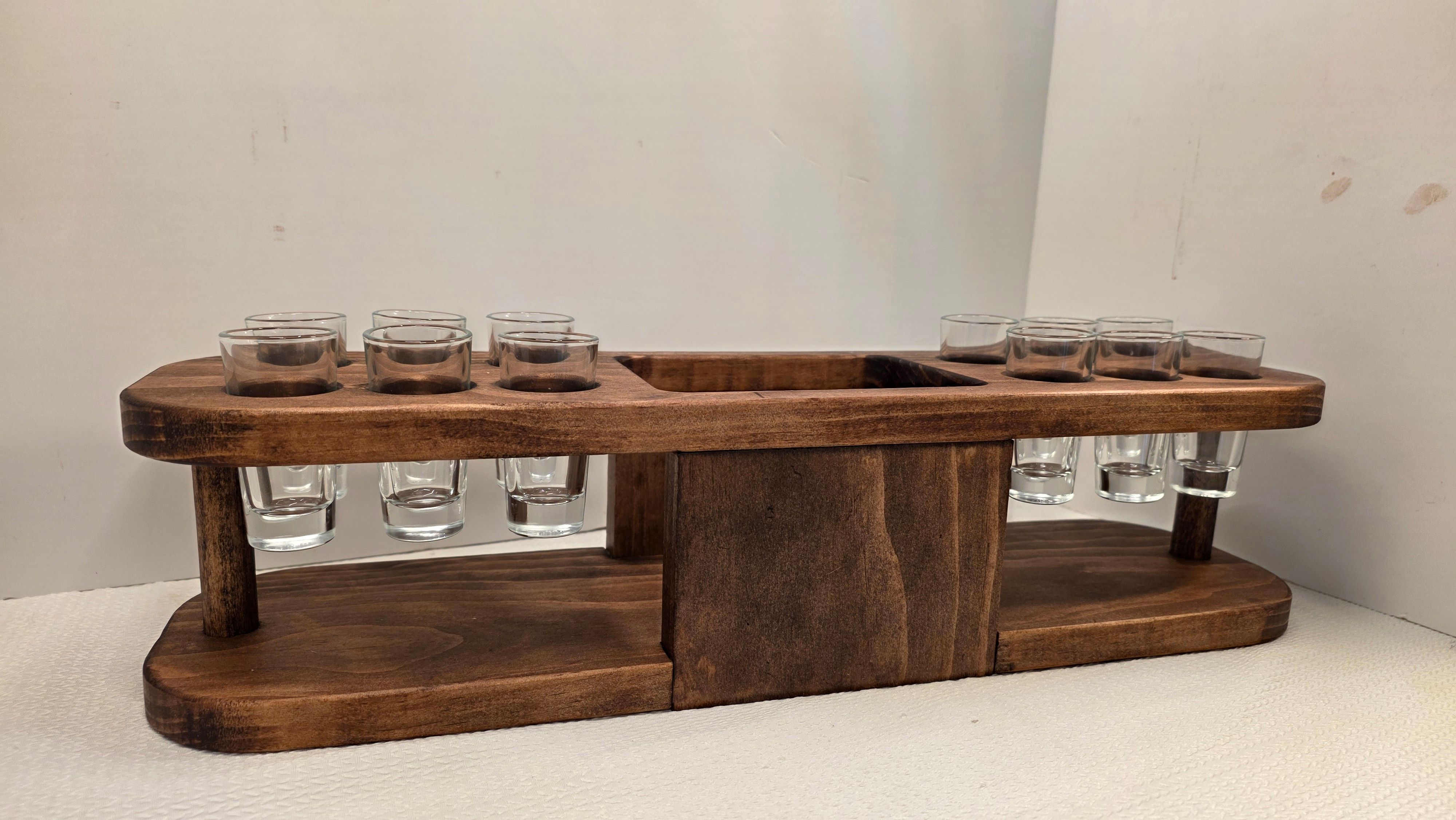 Wooden shot glass rack holding twelve clear glasses