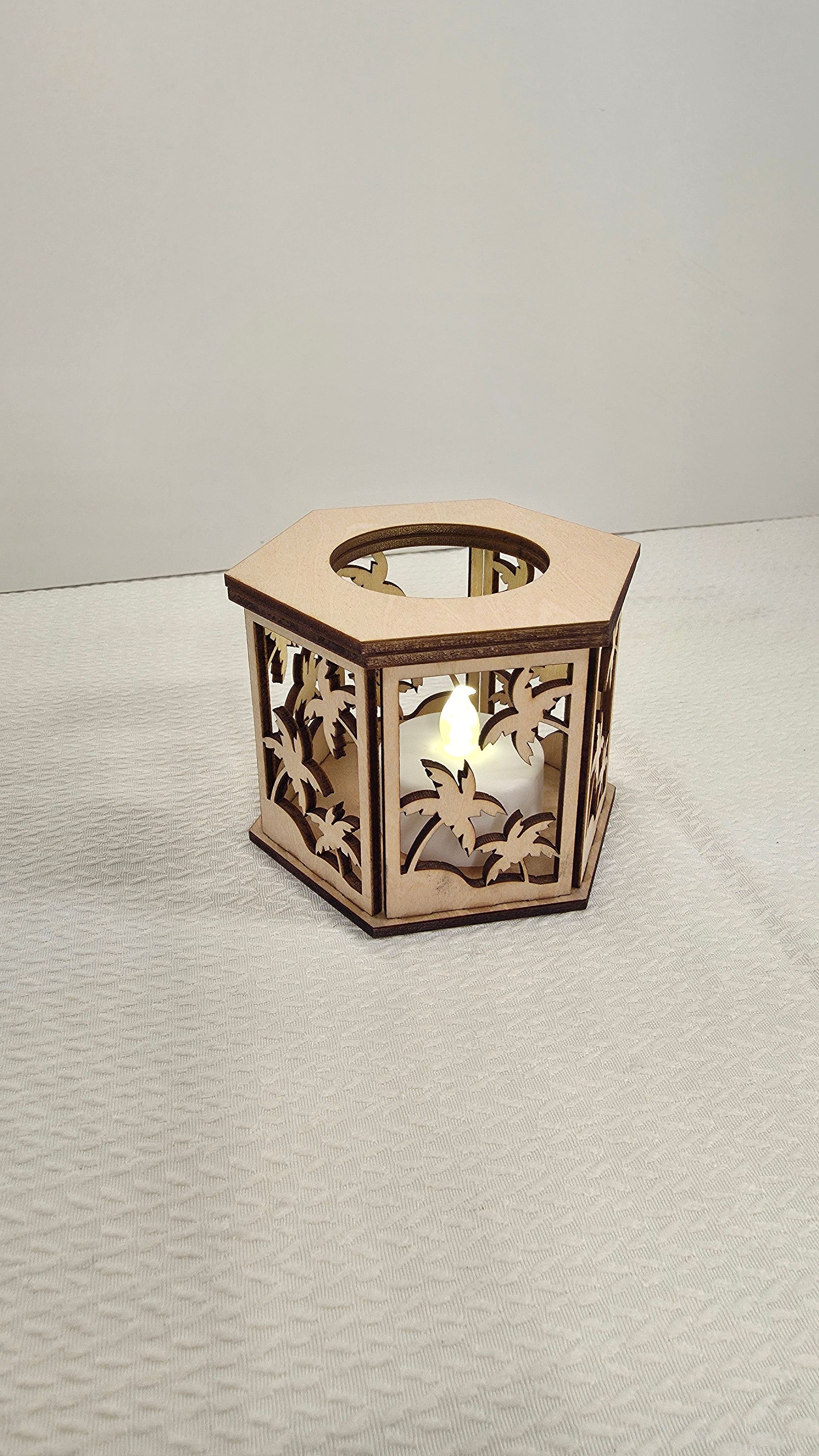 Hexagonal wooden lantern with palm tree cutouts
