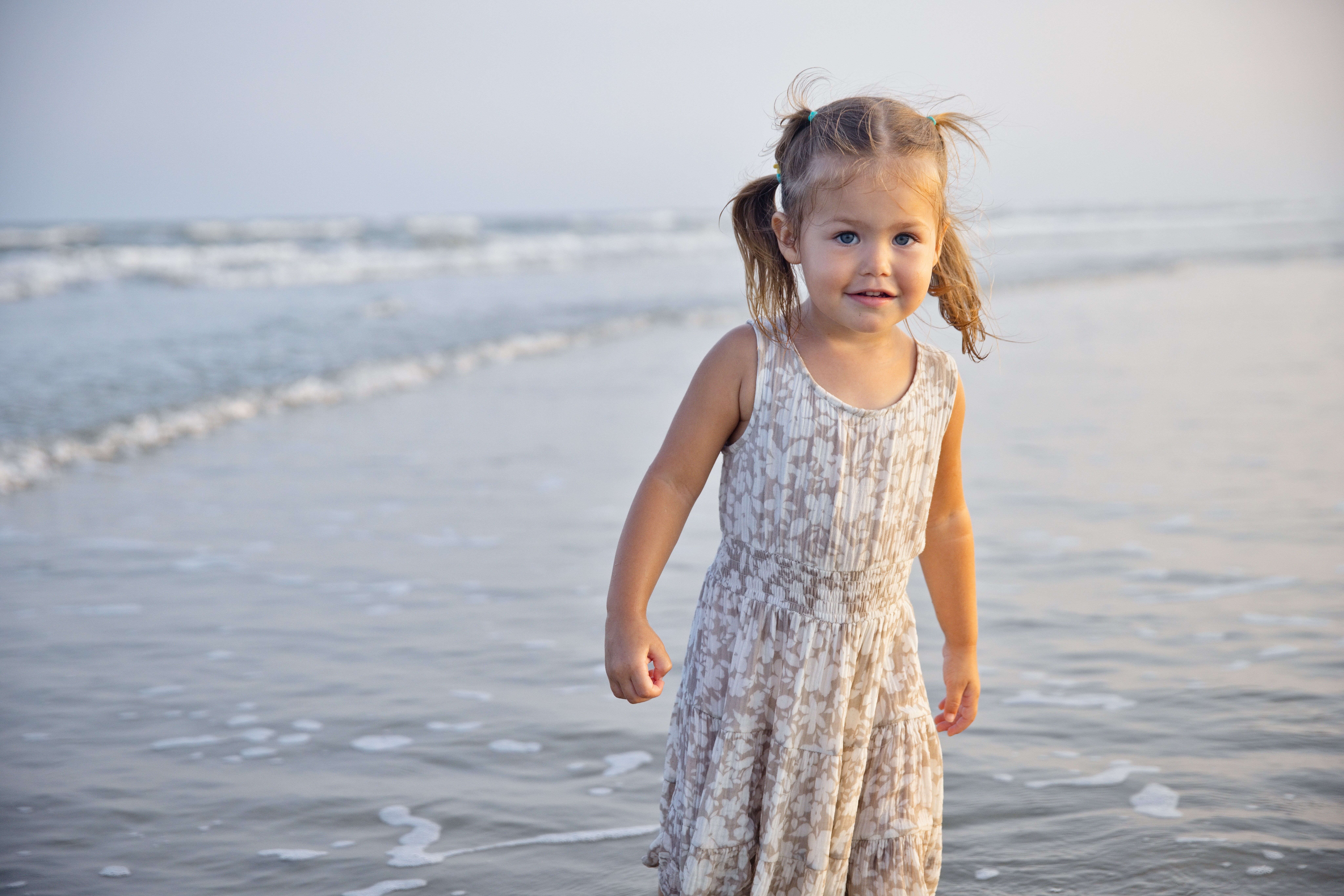 Little girl in shallow water at the beach