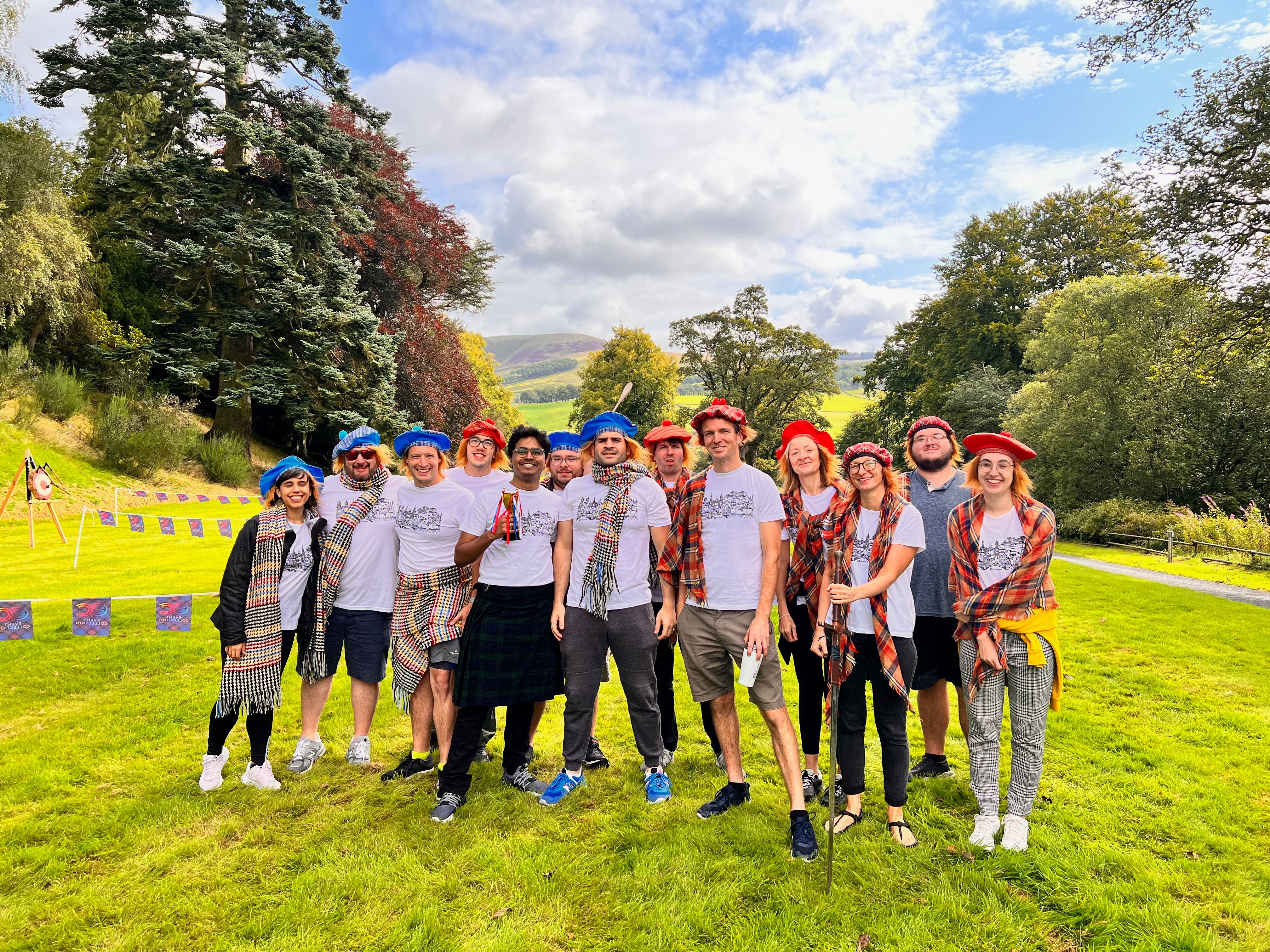 Event Collection team building — group of participants in branded white T-shirts enjoying an outdoor corporate team building event