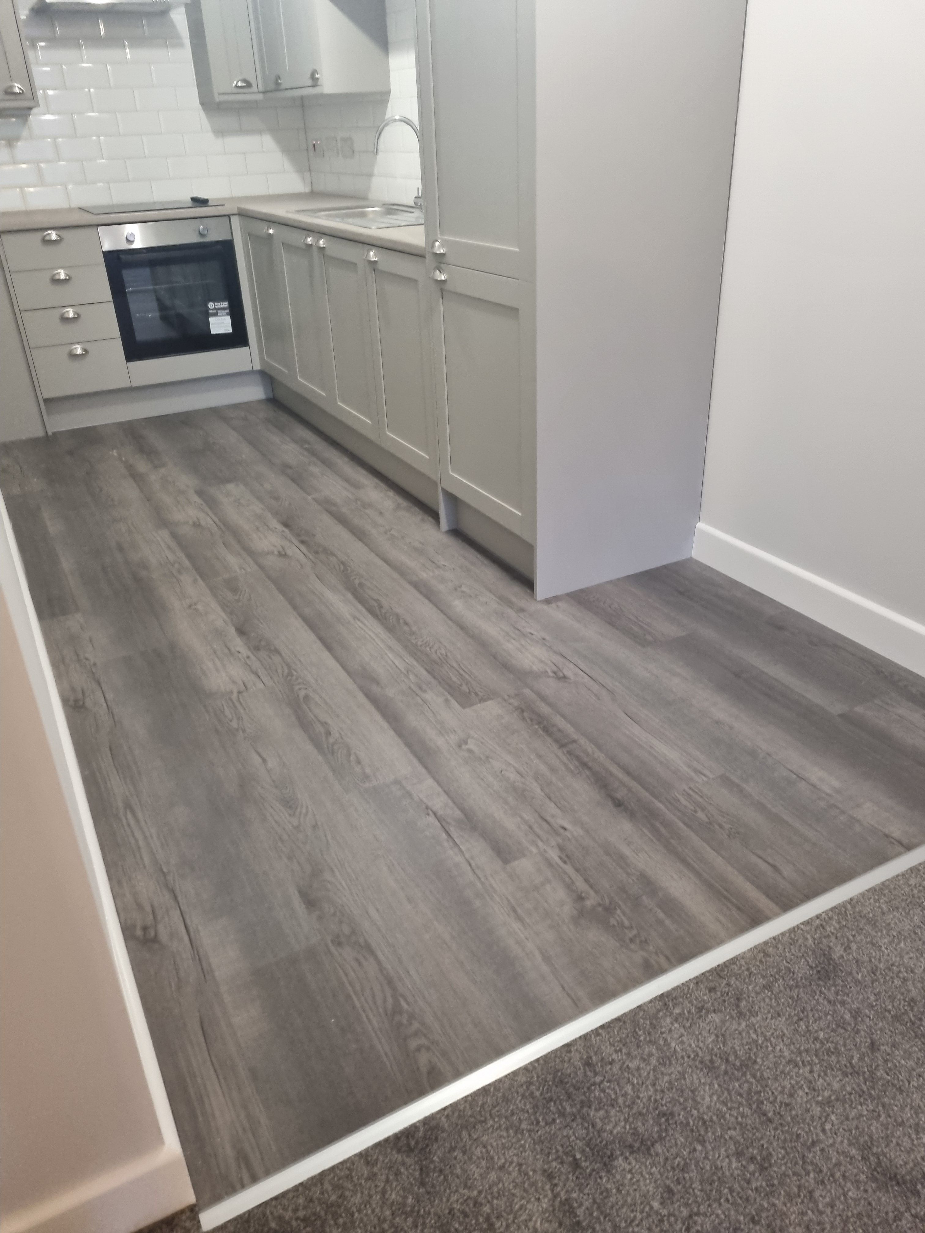 Kitchen with SPC flooring and carpet transition